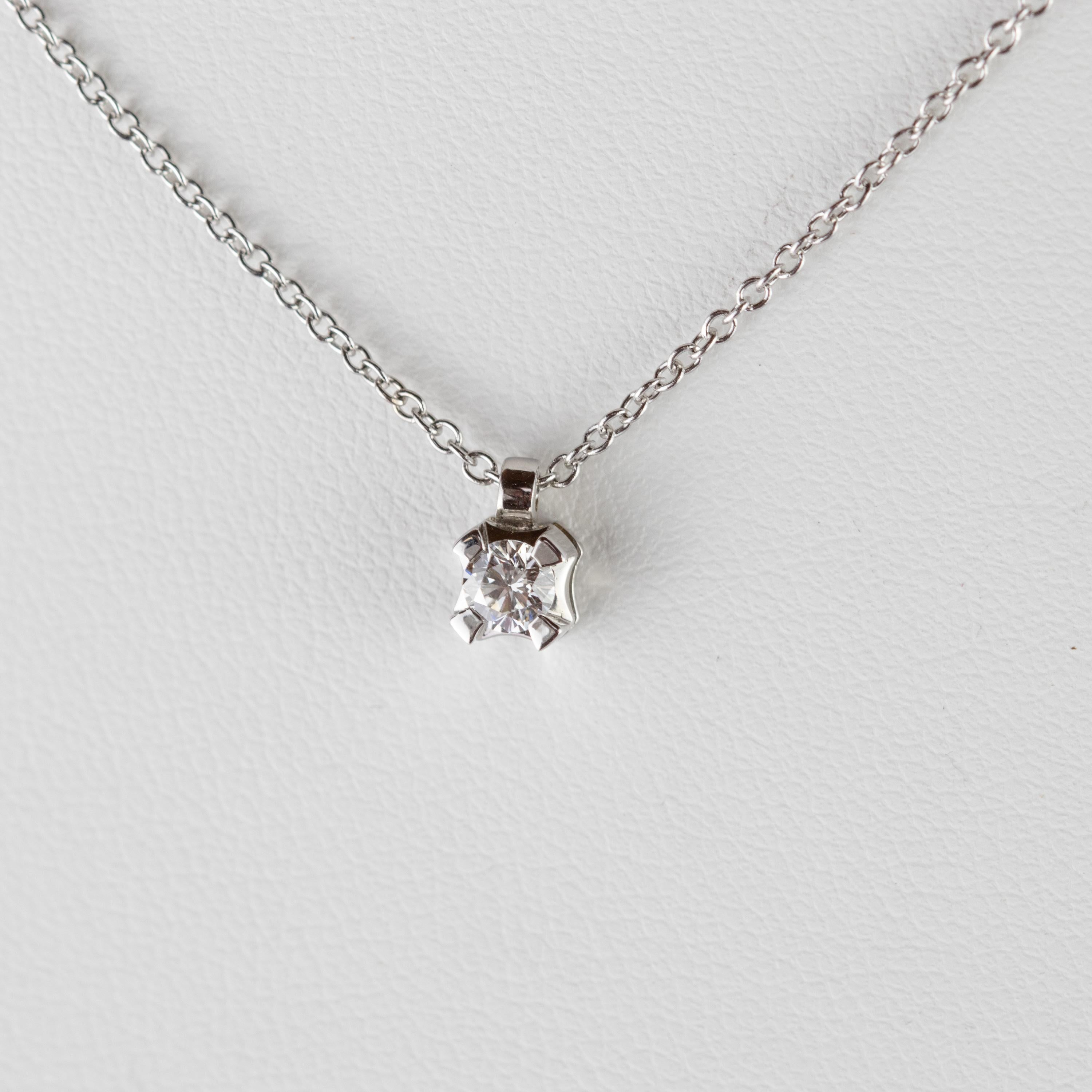 Modèle carré en or blanc 18 carats unique en son genre, contenant un diamant rond brillant de 0,2 carat. Une pièce solitaire agrémentée d'une chaîne de 44 cm en or blanc 18k.
 
Le diamant est un symbole d'innocence, d'amour et de pureté. Adopter la
