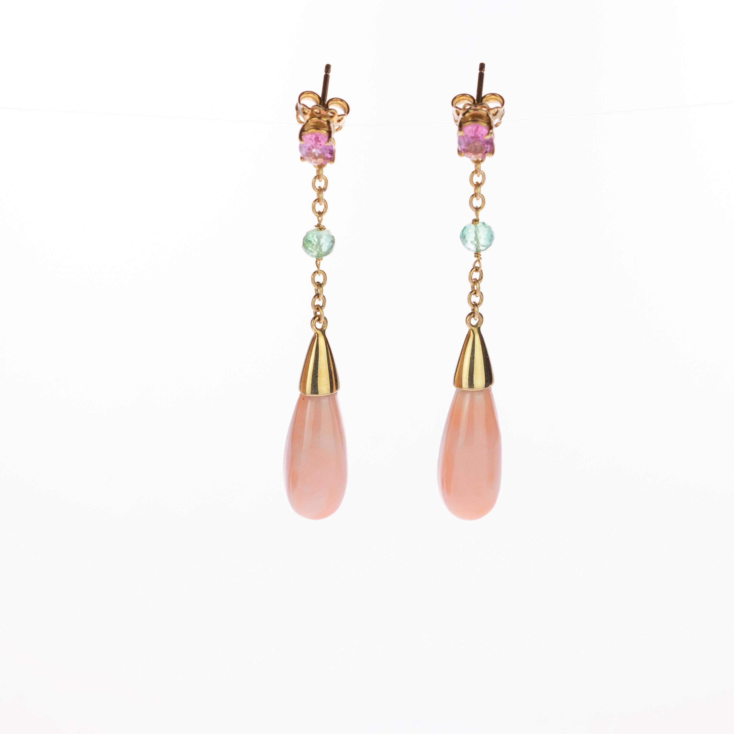 Ein bezaubernder und strahlender Tropfenohrring. schmuckstück aus 18 Karat Gelbgold, hervorgehoben durch einen hellrosa Korallentränenstein. An einer zarten Goldkette sind ein violetter Turmalin und ein hellgrüner Smaragd befestigt. Kleine