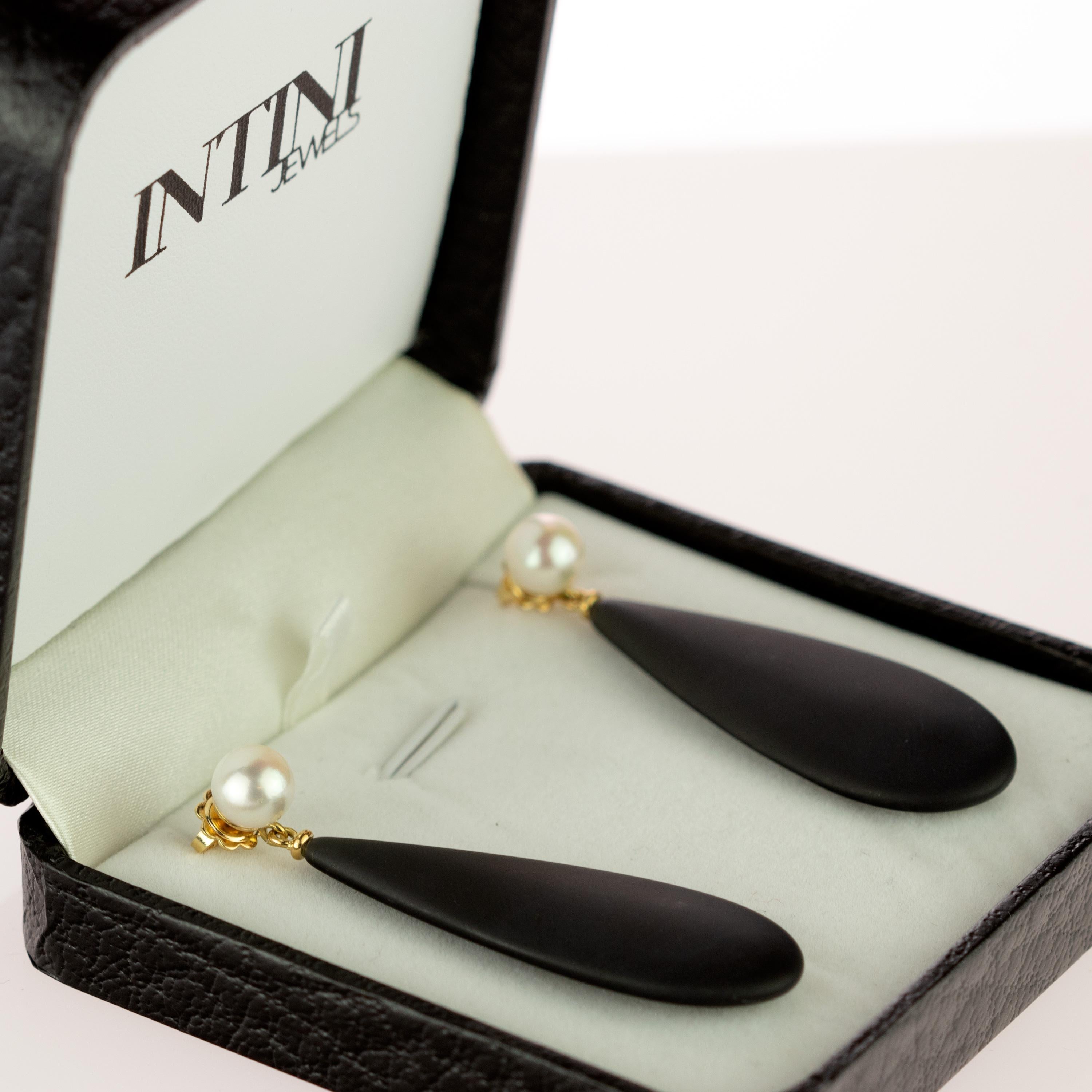 Crafted earrings of natural pearls with an stunning black agate pear teardrop design that combine voluminous round shapes with a matte black color. Resulting in flat, free-spirited pieces with a charming elegance. Held by 18 karat yellow gold that