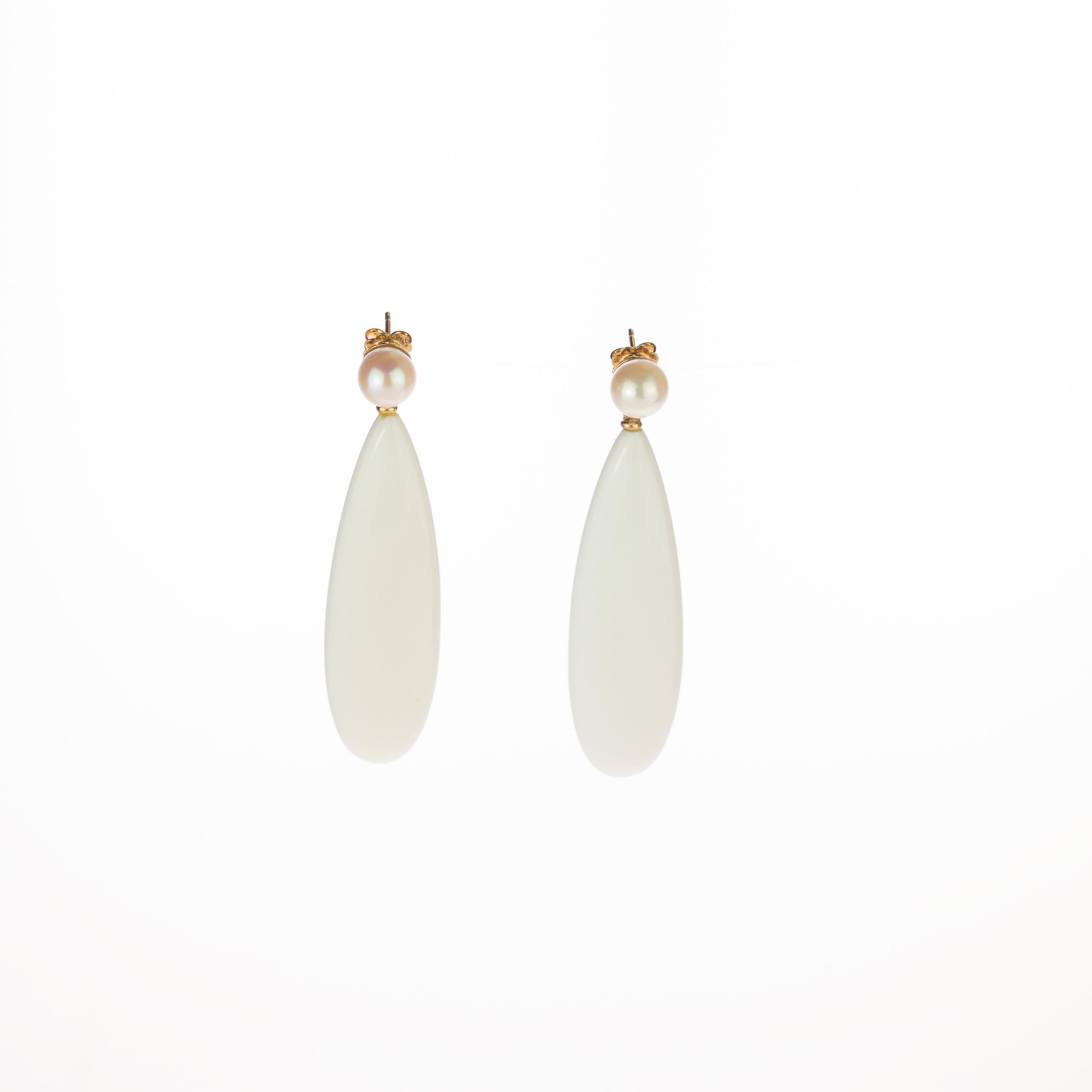 Crafted earrings of natural pearls with an stunning white agate pear teardrop design that combine voluminous round shapes with a matte white color. Resulting in flat, free-spirited pieces with a charming elegance. Held by 18 karat yellow gold that