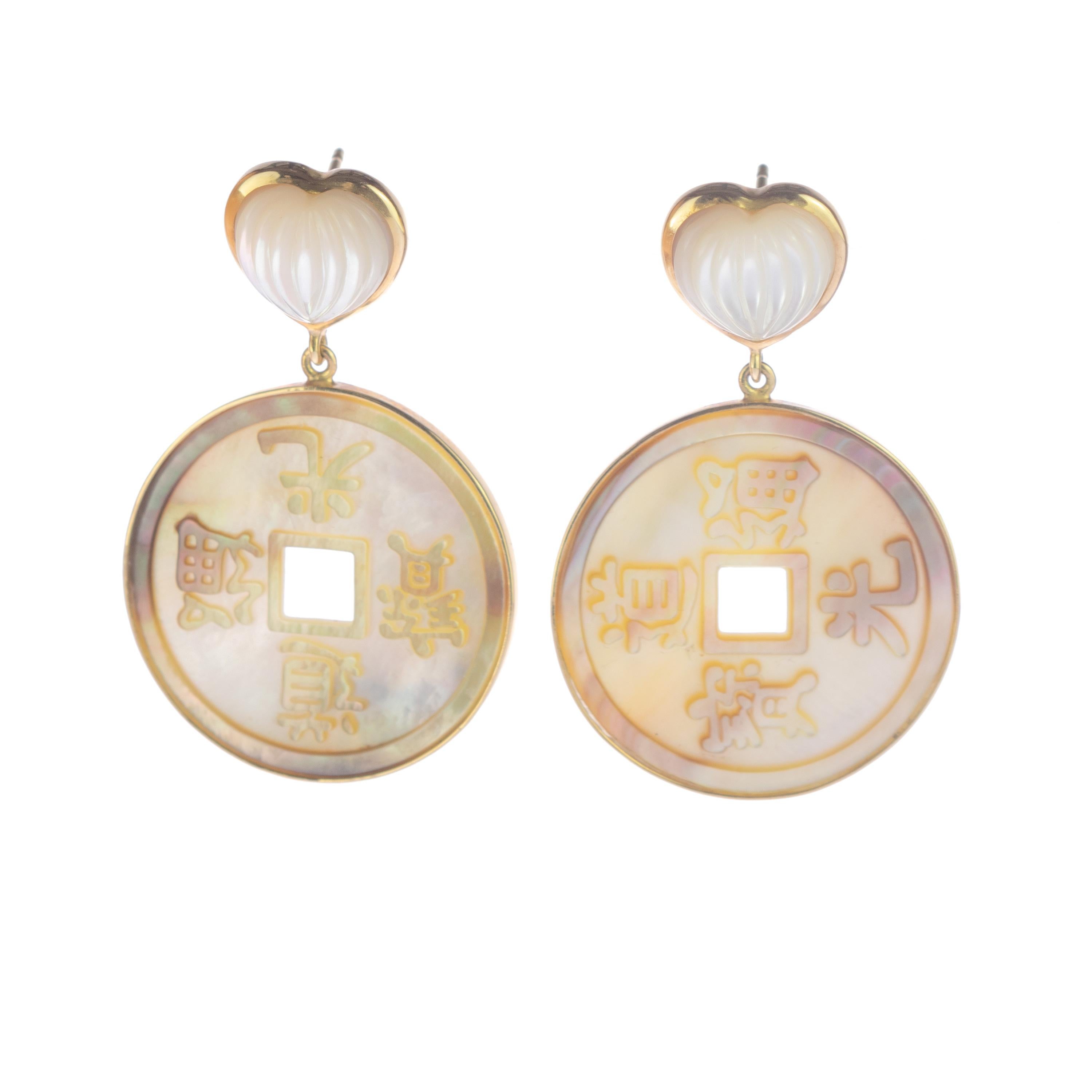 Artisan earrings setted in 18 karat yellow gold that holds a perfectly crafted heart shaped mother of pearl earrings that hold a round mother of pearl chinese coin design. The chinese symbols of love, wisdom, success and hope are enhanced by the