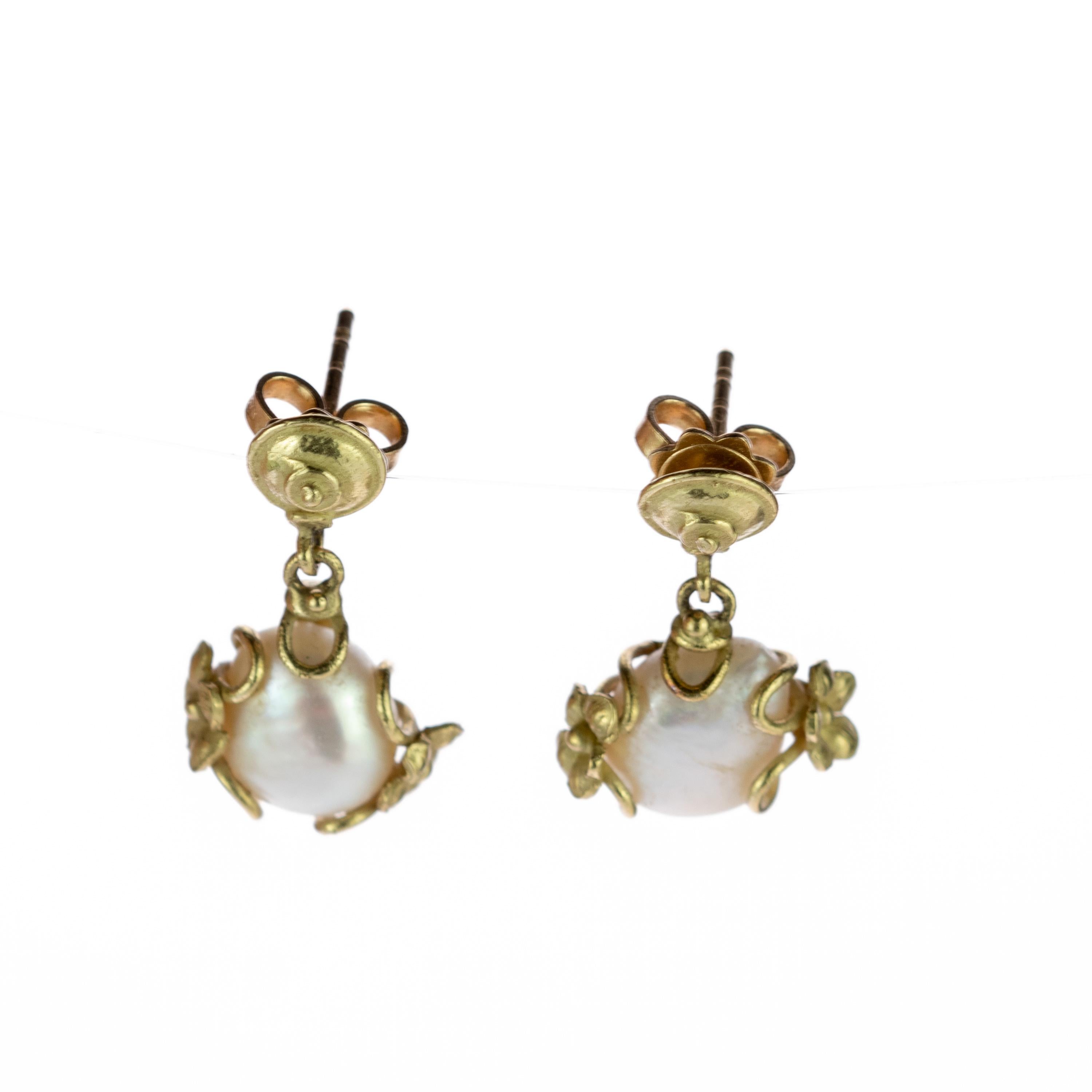 Plongez dans le monde précieux de la nature et de l'exquisité avec cette pièce unique de design italien. des perles d'eau douce naturelles de 22 carats pleines de charme entourées d'un motif unique de fleurs doucement entrelacées en or jaune 18