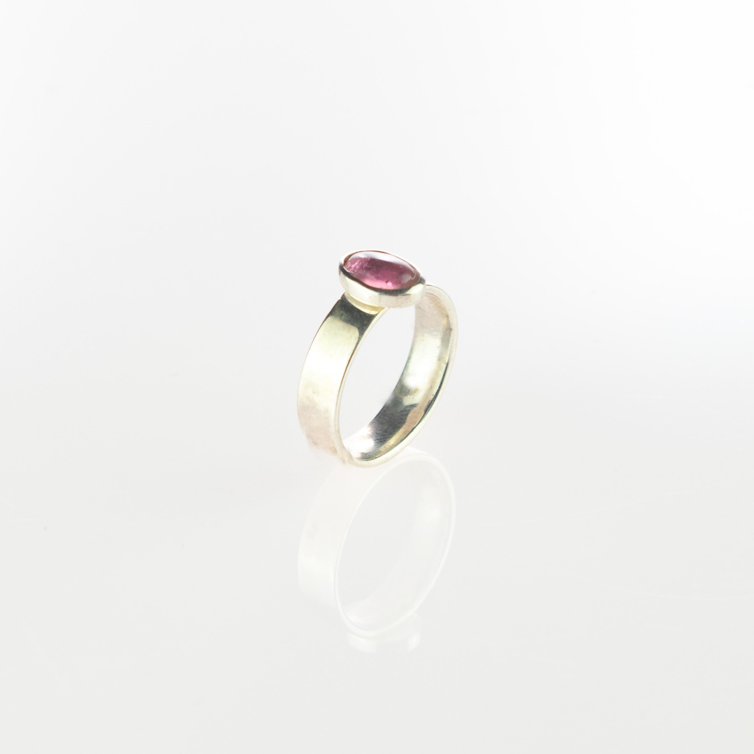 Pink purple tourmaline gemstone with an oval cabochon design embellished in a sterling silver ring. This gem will fill your daily elegant outfits with a modern and simple design. This gemstone ​​represents the stone of earth and serenity, delight