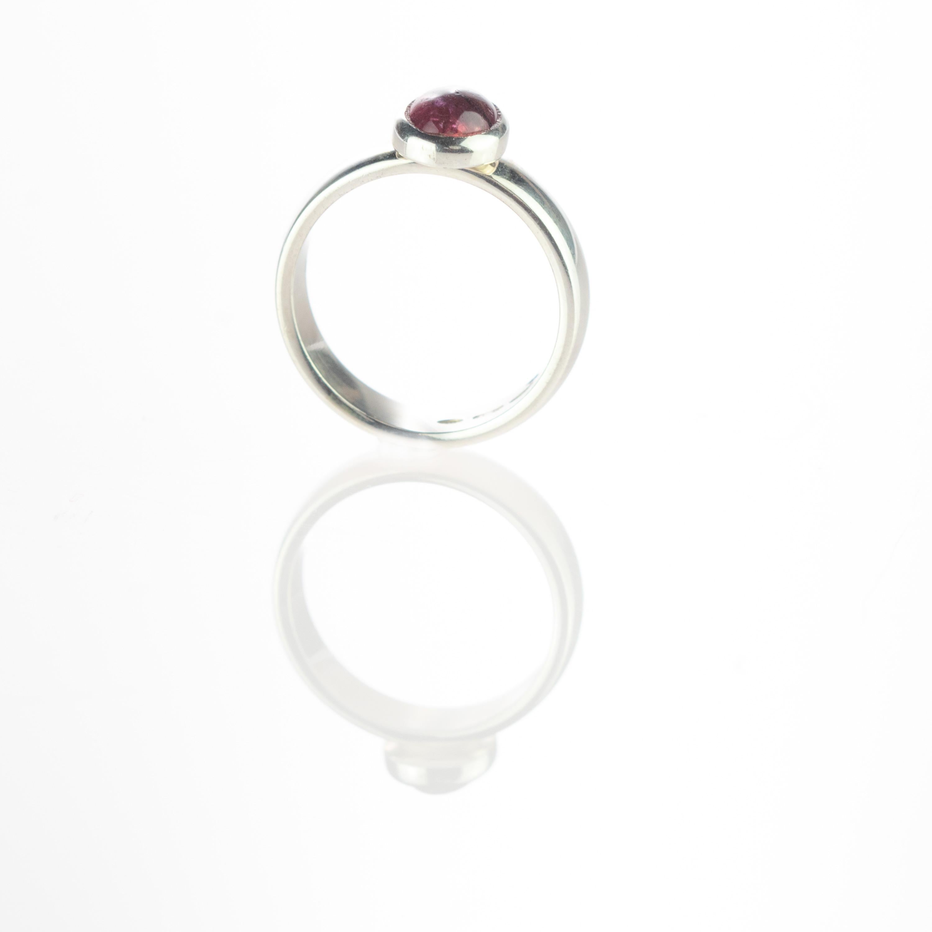 Purple tourmaline gemstone with an oval cabochon design embellished in a sterling silver ring. This gem will fill your daily elegant outfits with a modern and simple design. The purple tourmaline ​​represents the stone of passion and sensuality,