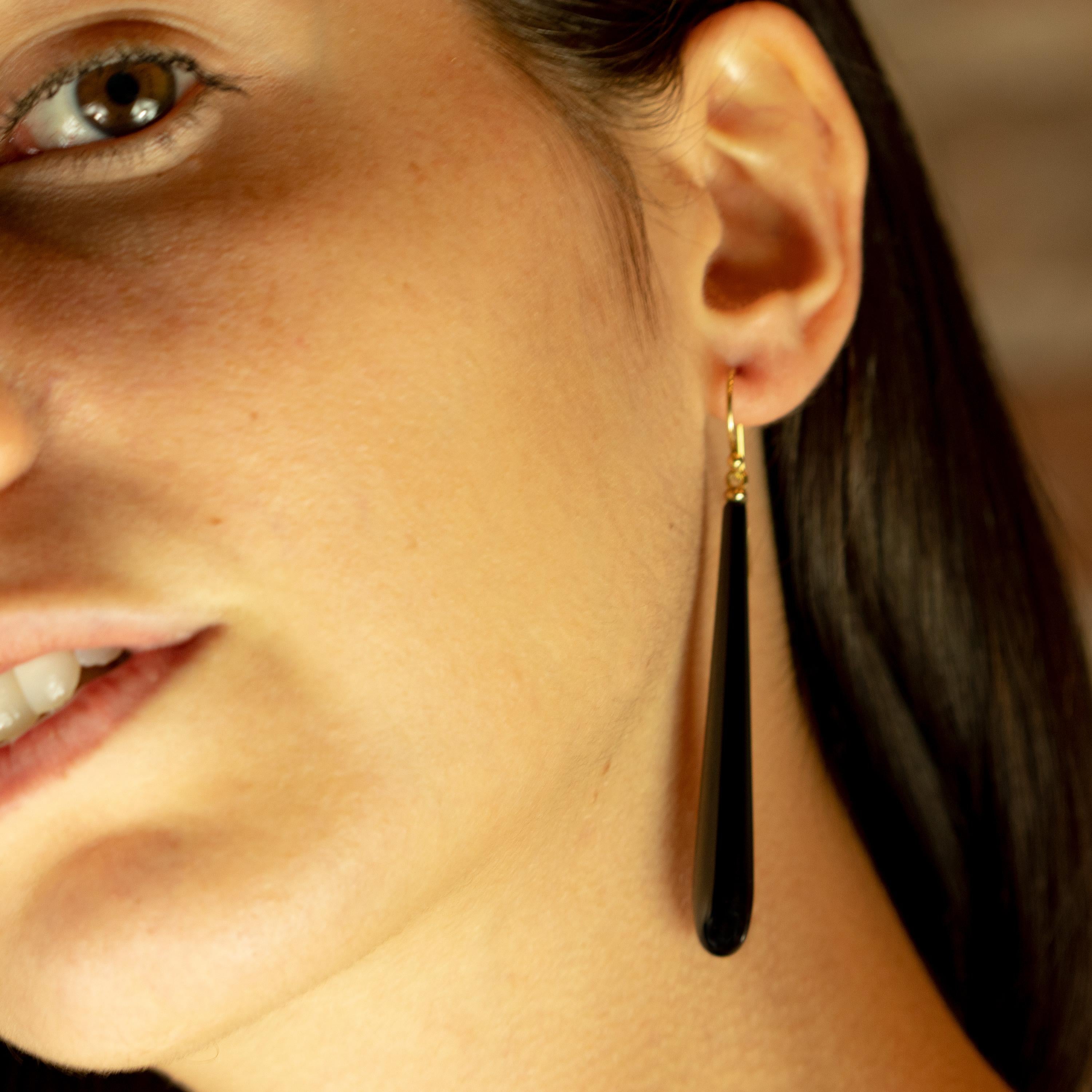 Intégrez à votre look personnel ces boucles d'oreilles en agate noire audacieuse maintenues par un or jaune 18 carats. Recréez le glamour sous sa seule forme : l'élégance et le confort. Une goutte d'eau moderne avec un design long et pendentif. 
