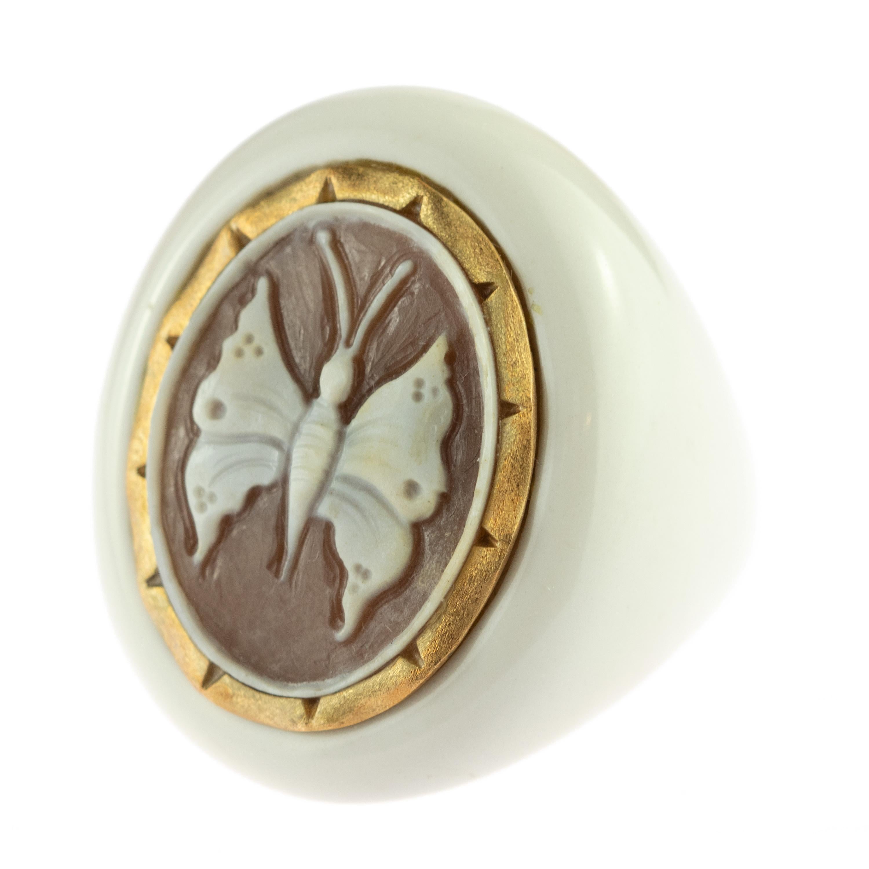 A unique and breathtaking jewel with a central carved sardonic shell representing a white butterfly, mounted on a white resin ring setting.. A precious jewel surrounded by 18 an karat yellow gold line creating a beautiful art piece. Marvelous