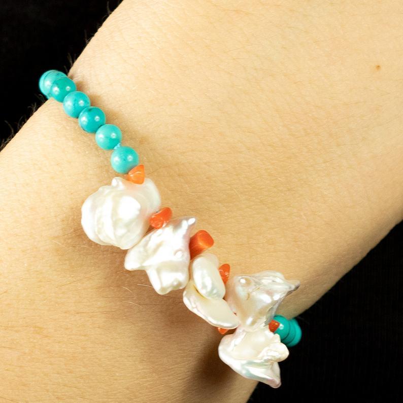 A delicate strand of turquoise beads with central mother of pearl and coral chips bracelet. Immerse yourself in the beauty of this uniquely designed bracelet with natural stones full of life and color. A hawaiian inspirational jewel which will match