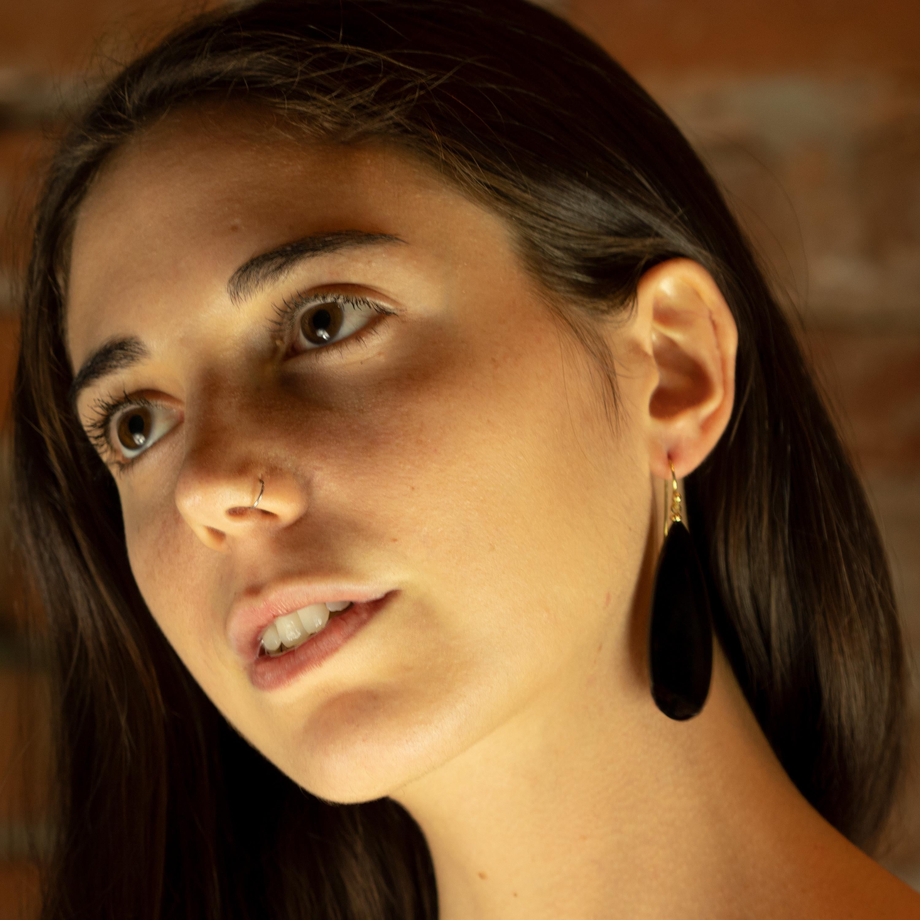 Orecchini a goccia in agata moderna che combinano forme voluminose con un colore nero opaco, dando vita a pezzi audaci, dallo spirito libero e dall'eleganza affascinante. Sostenuto da un delicato pendaglio in oro giallo 18 carati.
 
Questi orecchini