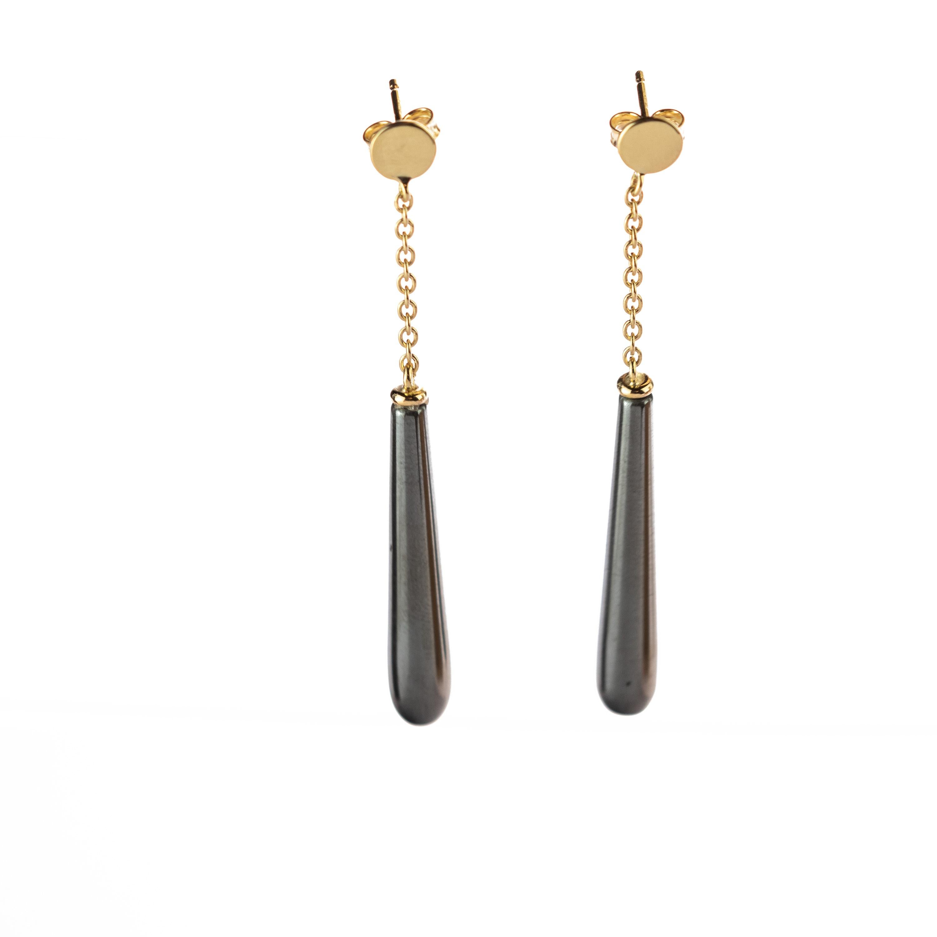 Include in your personal look these grey bold hematite earrings holded by a 18 karat yellow gold chain with a circular gold piece on top. Recreate glamour in its only form: elegance and comfort. A modern and light teardrop with long and design. 
