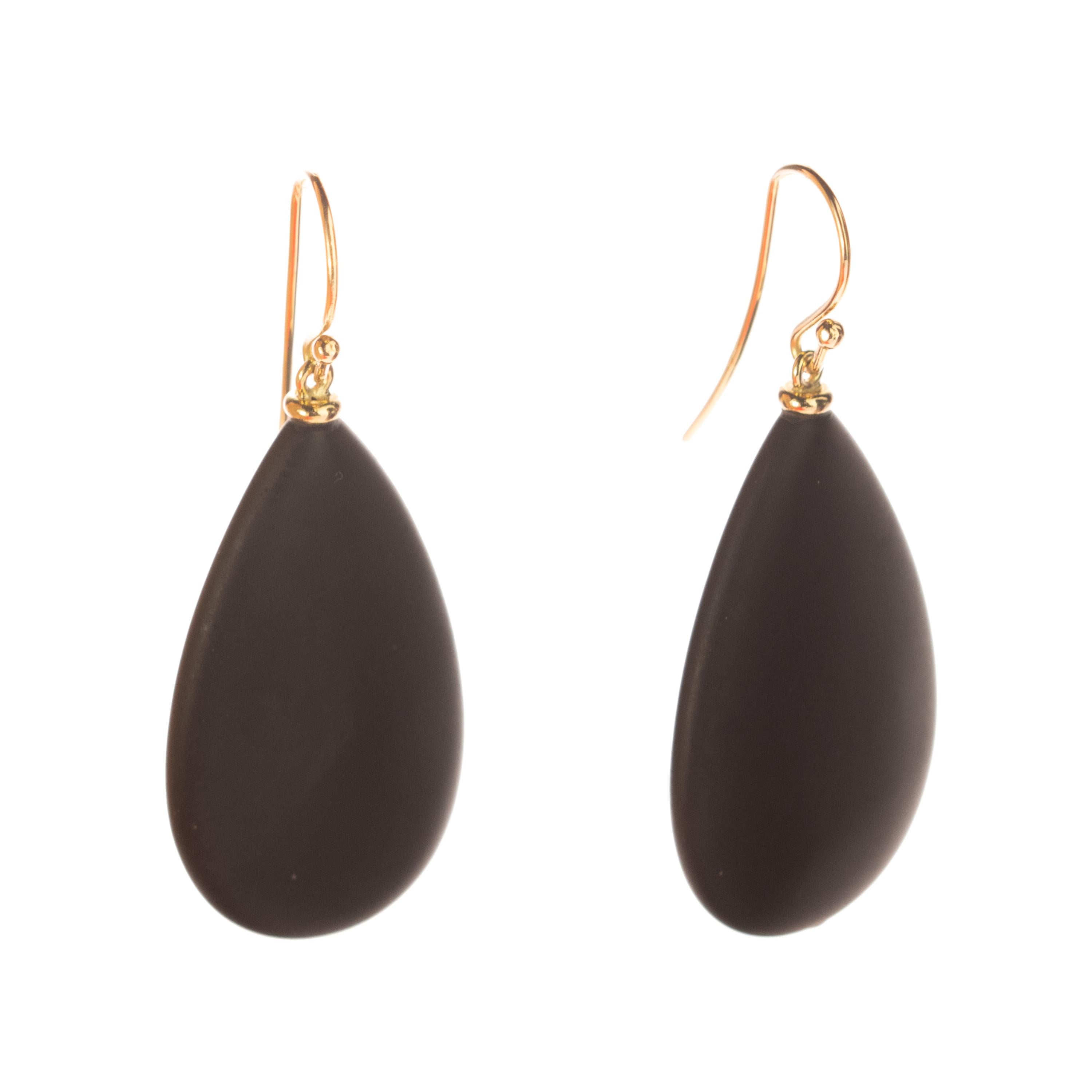 Boucles d'oreilles modernes en forme de goutte d'agate qui combinent des formes volumineuses avec une couleur noire mate, ce qui donne des pièces audacieuses, libres d'esprit et d'une élégance charmante. Maintenu par un délicat pendentif en or jaune
