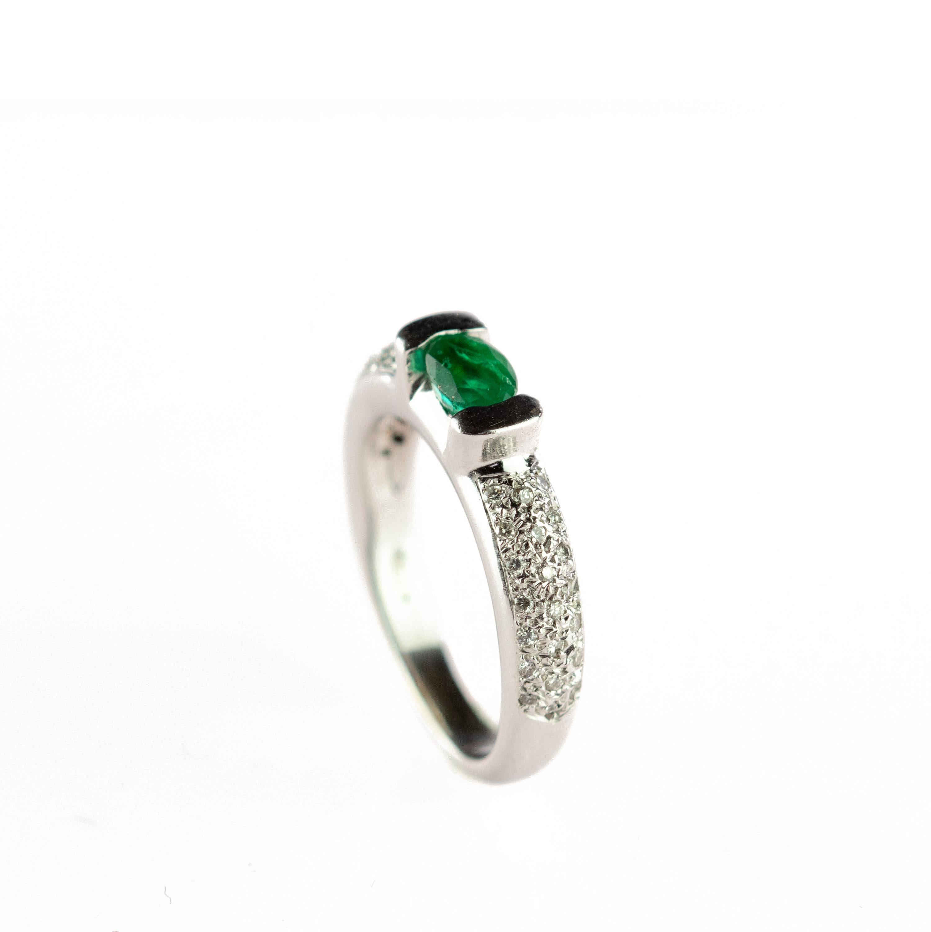 Amazing and stunning emerald stone with a brilliant cut that is surrounded by 18 karat white gold. Embellished by numerous diamonds that create an elegant cocktail jewel piece enhanced by a solitaire look in a unique way. 
 
This ring is inspired by