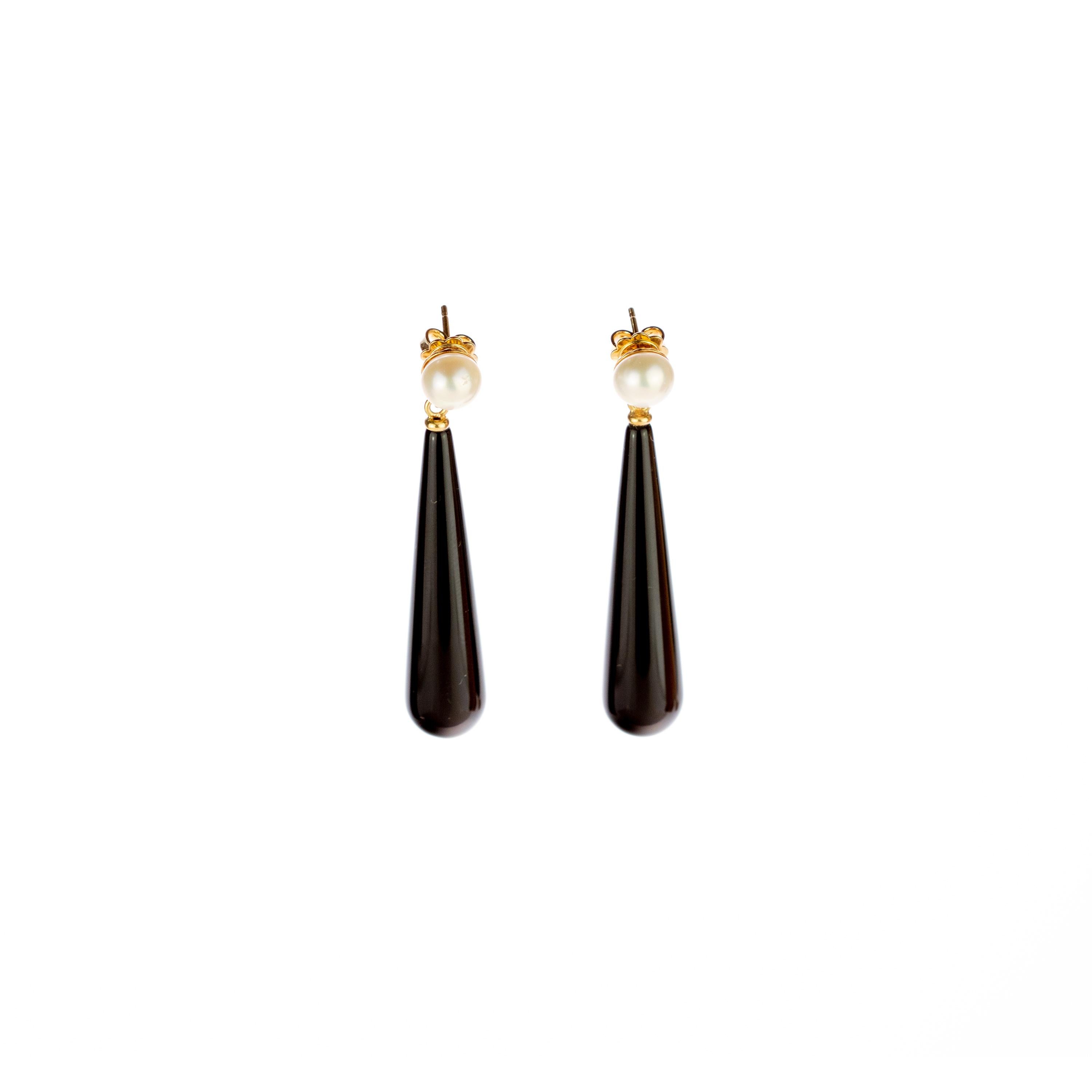 Fresh and youthful black bold agate earrings with a round natural pearl on top. Holded by a 18 karat yellow gold that recreates a stylish piece of jewelry that can highlight any look. The perfect touch full of modernity with a tear drop and dangle