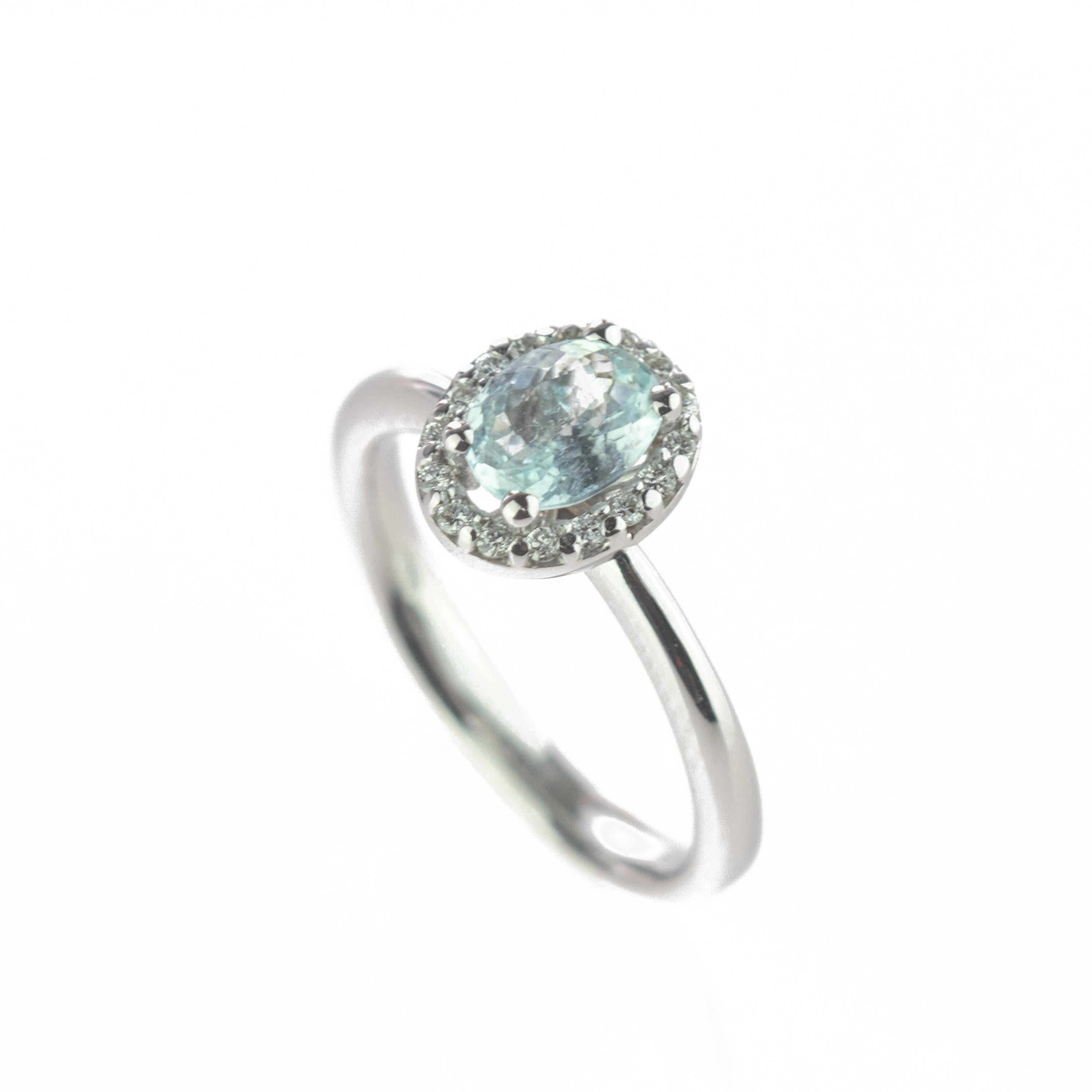 An impressive engagement and bridal ring with clear natural 0.2 carat diamonds surroininding a unique and marvelous blue paraiba tourmaline on a 18 karat white gold band. This epic statement ring shapes a breathtaking handmade clover with four soft