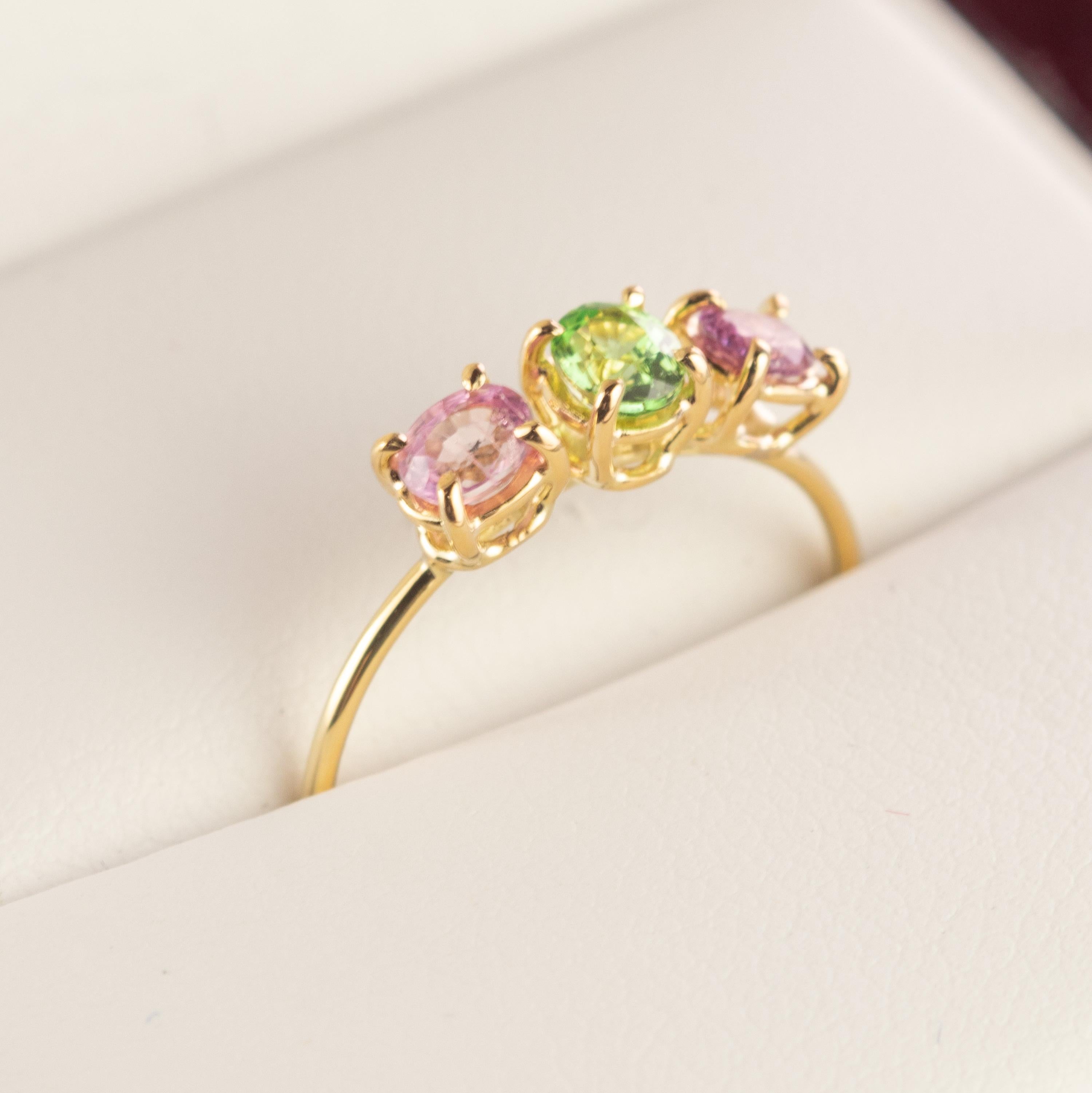 Marvelous handmade 18 karat yellow gold trilogy thin ring embellished with stunning pink sapphires and tsavorite. Open your intuition and enhance your senses to love. The three bands depict fidelity, friendship and love, which has made Trinity an