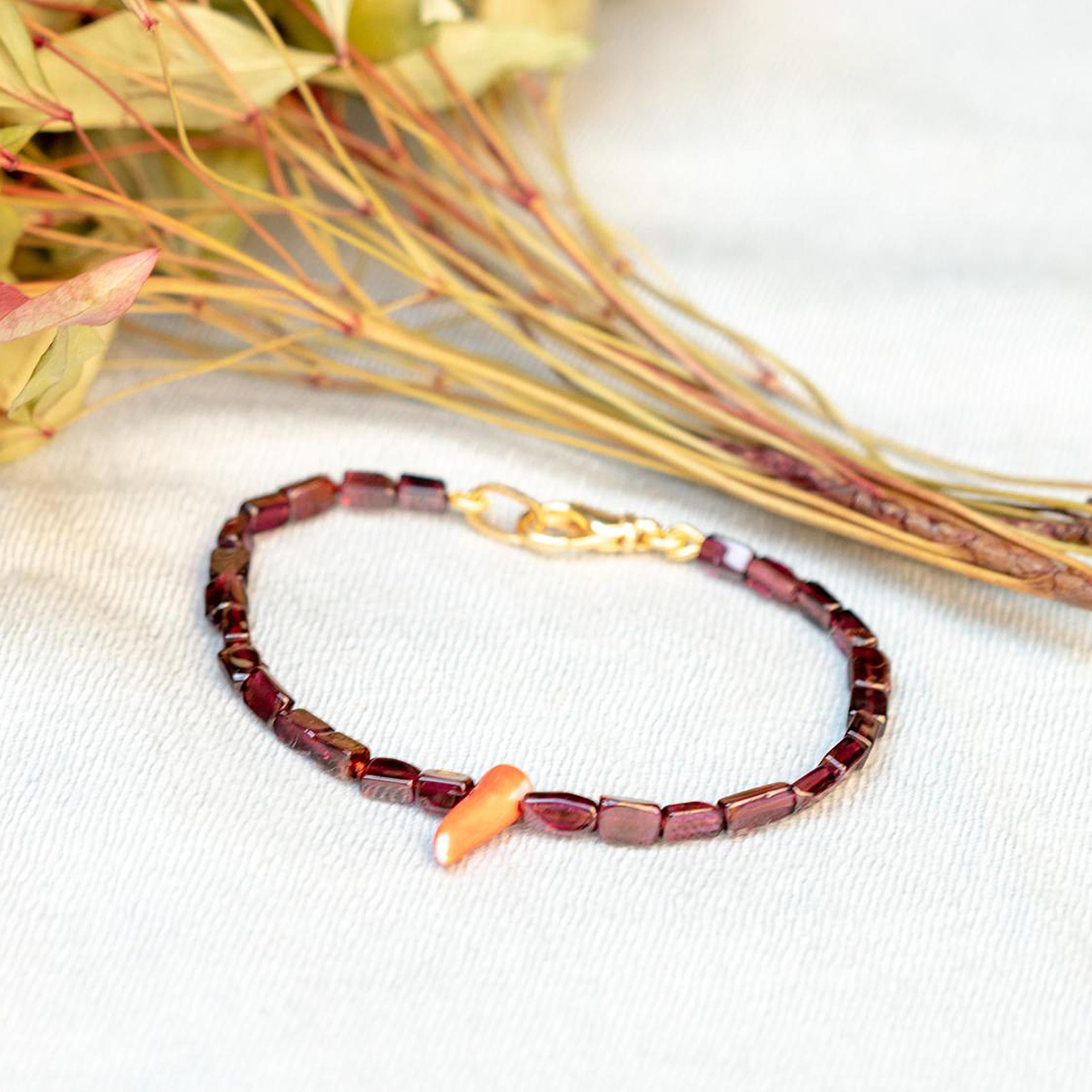 Un design fresco realizzato con perline di granato viola a forma di rettangolo. Immergiti nella bellezza di questo bracciale dal design unico con pietre naturali piene di vita e di colore. Un gioiello d'ispirazione hawaiana che si abbina a qualsiasi