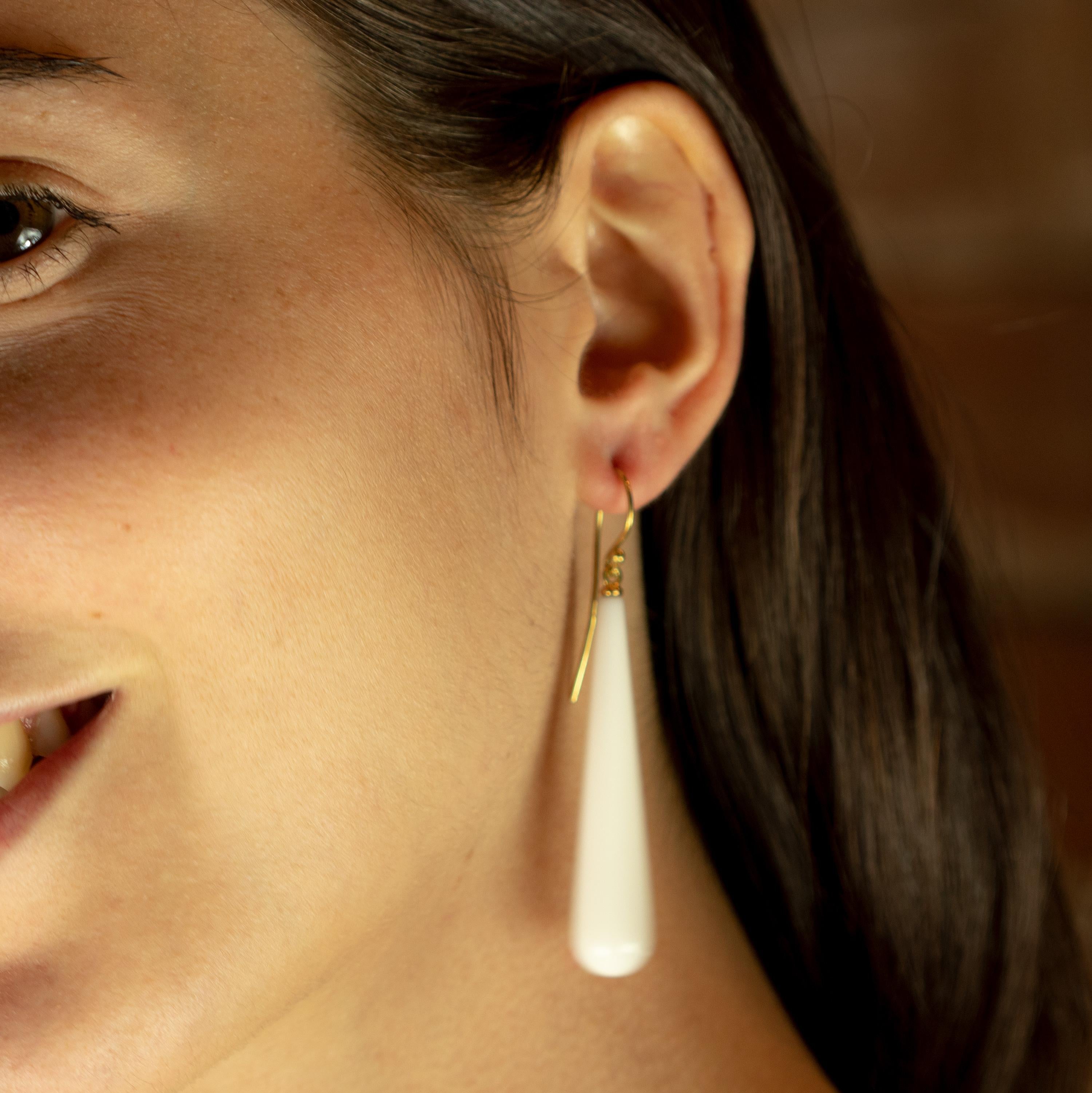 Fresh and youthful white bold long tear agate earrings. Holded by a 18 karat yellow gold that recreates a stylish piece of jewelry that can highlight any look. The perfect touch full of modernity with a tear drop and dangle design.
 
These earrings