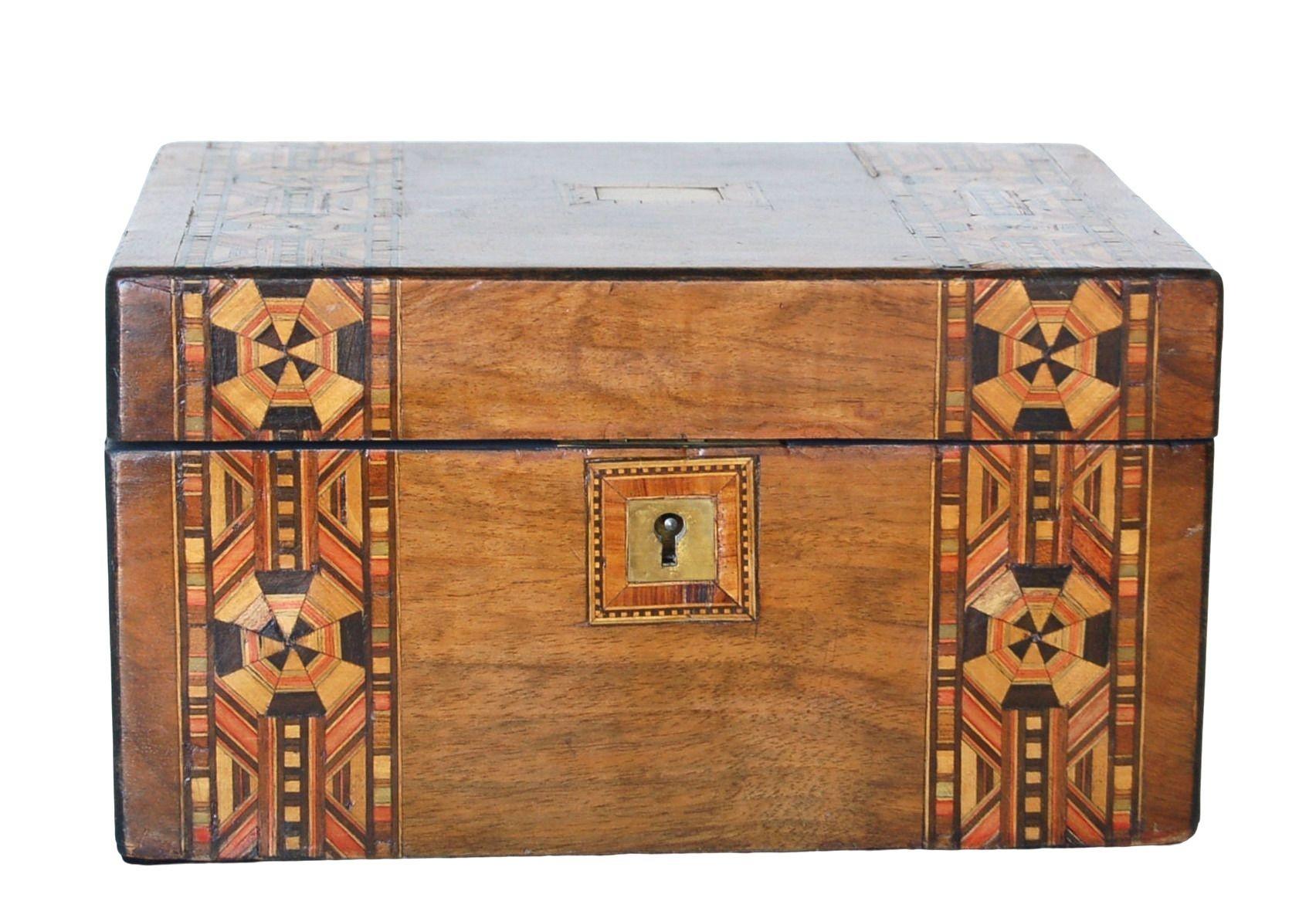 This exquisite marquetry inlaid wood box showcases intricate craftsmanship, highlighted by a decorative metal center accent. Complete with a functional skeleton key, the box opens to reveal a paper and fabric-lined interior, perfect for storing