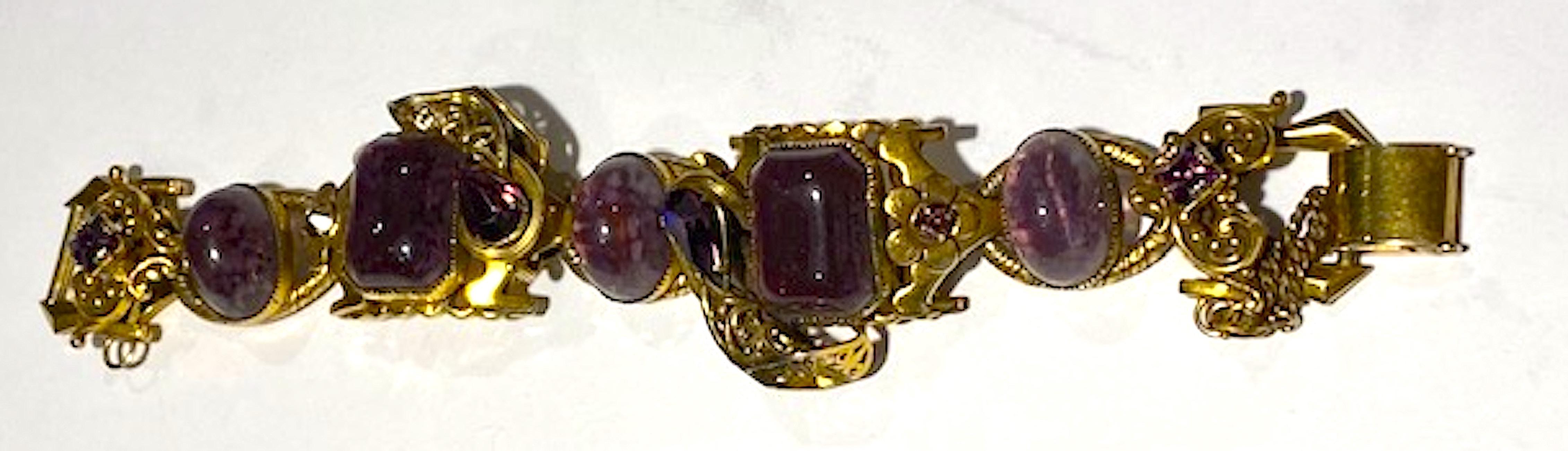 A beautifully crafted and intricate 1940s bracelet. Attributed to the West German jewelry company Henkell & Grosse who produced jewelry for Christian Dior in the 1950s and 60s. The oval and rectangular purple glass cabochons were made with