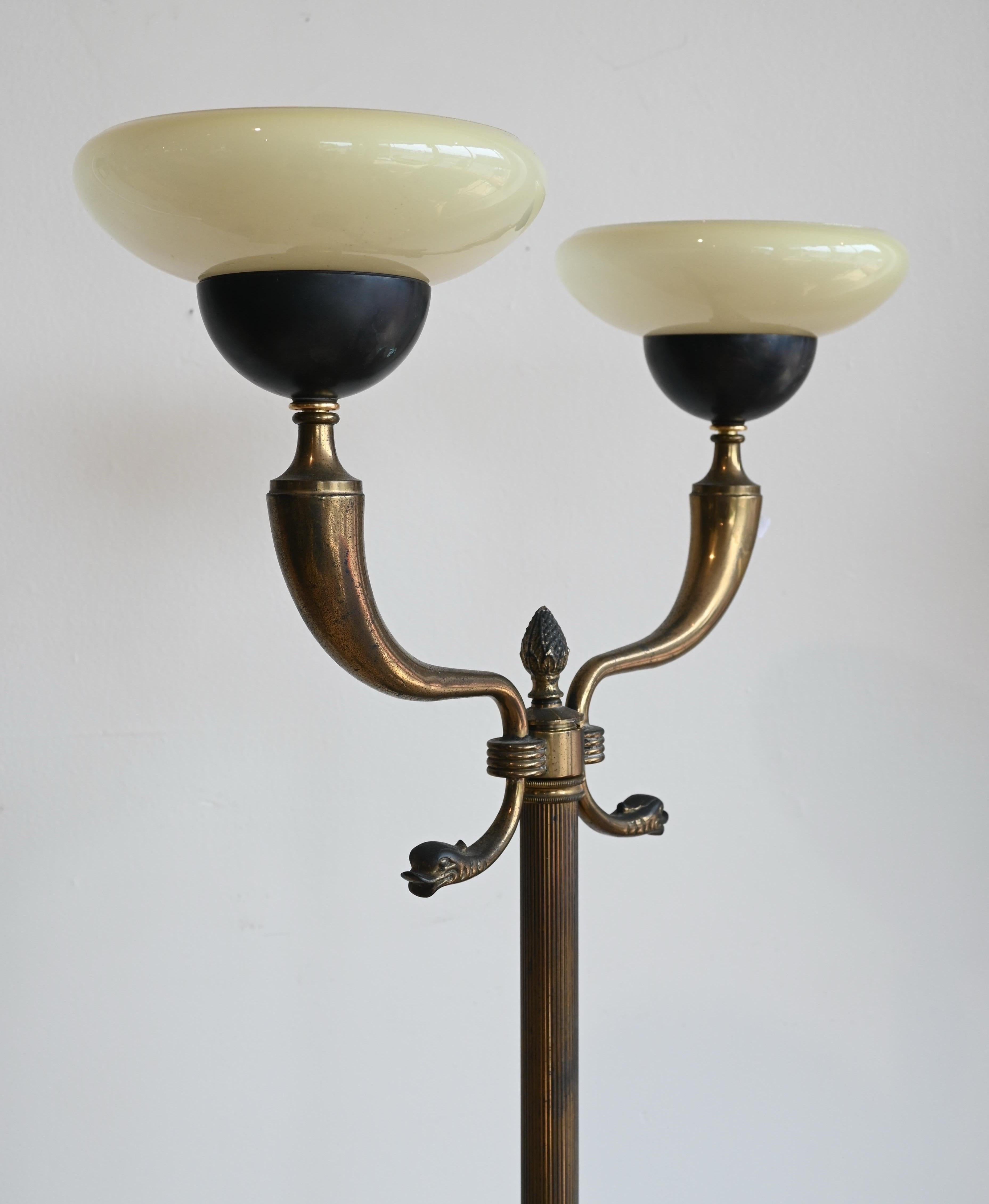 Un superbe lampadaire d'époque Art déco. Figures en laiton aux détails complexes avec deux abat-jour en verre. Corps nervuré et base solide. 