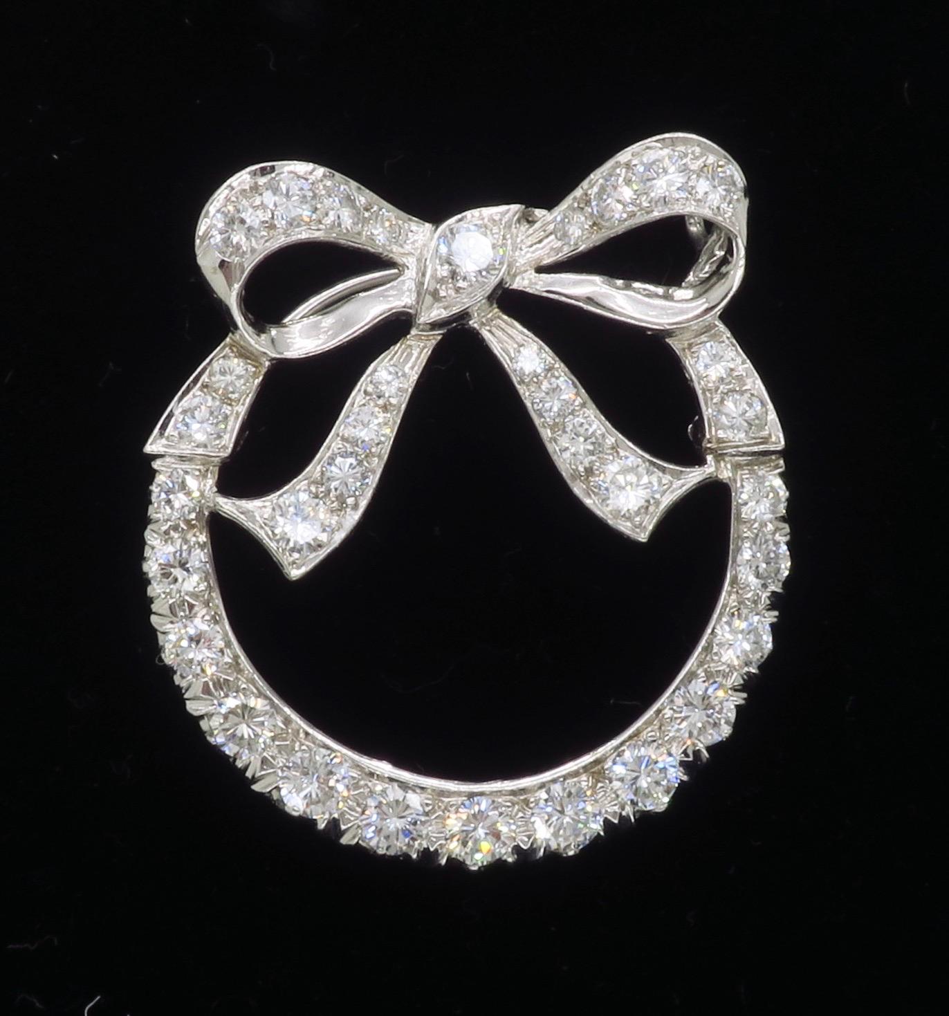 Vintage bow diamond brooch crafted in 14k white gold.

Diamond Carat Weight: Approximately 1.95CTW
Diamond Cut: Round Brilliant Cut Diamonds
Color: Average E-F
Clarity: Average VS
Metal: 14k White Gold 
Weight: 5.8 Grams
Length: Approximately 1