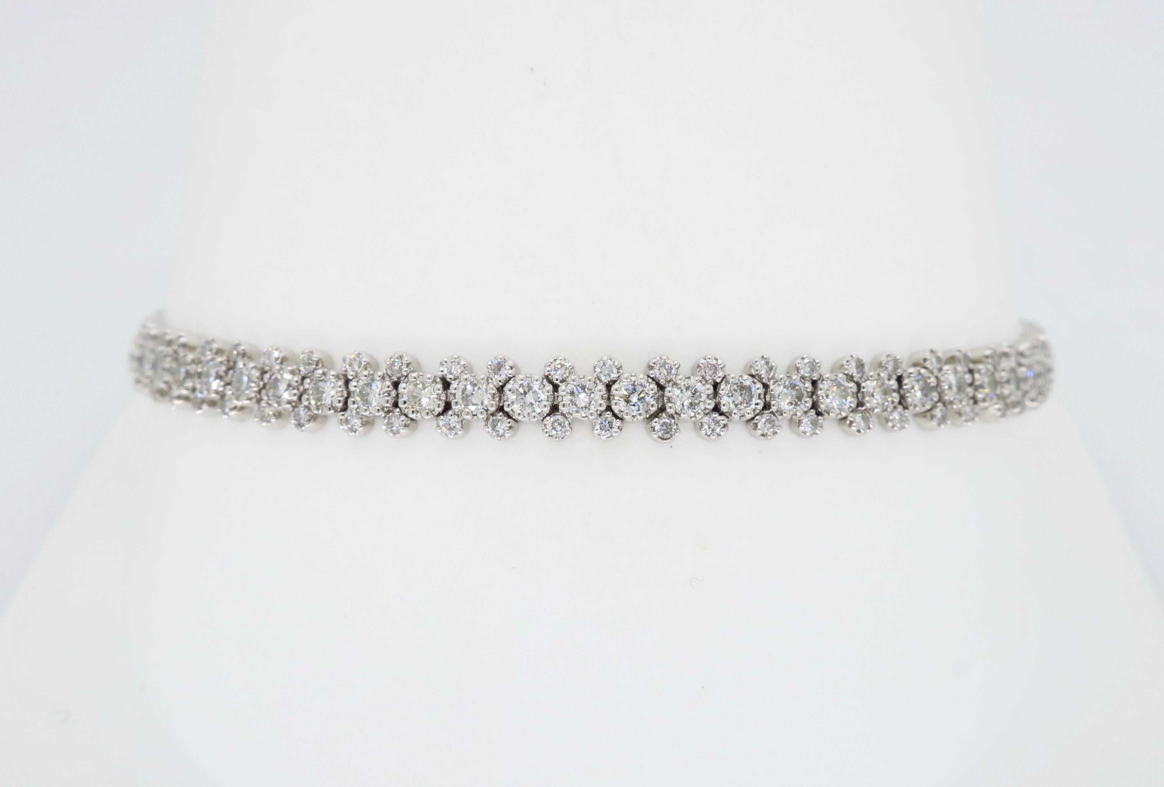 Unique cluster style diamond tennis bracelet crafted in 18k white gold. 

Diamond Carat Weight: Approximately 2.90CTW
Diamond Cut: Round Brilliant Cut 
Color: Average G-I
Clarity: Average VS-I
Metal: 18K White Gold
Marked/Tested: Stamped 