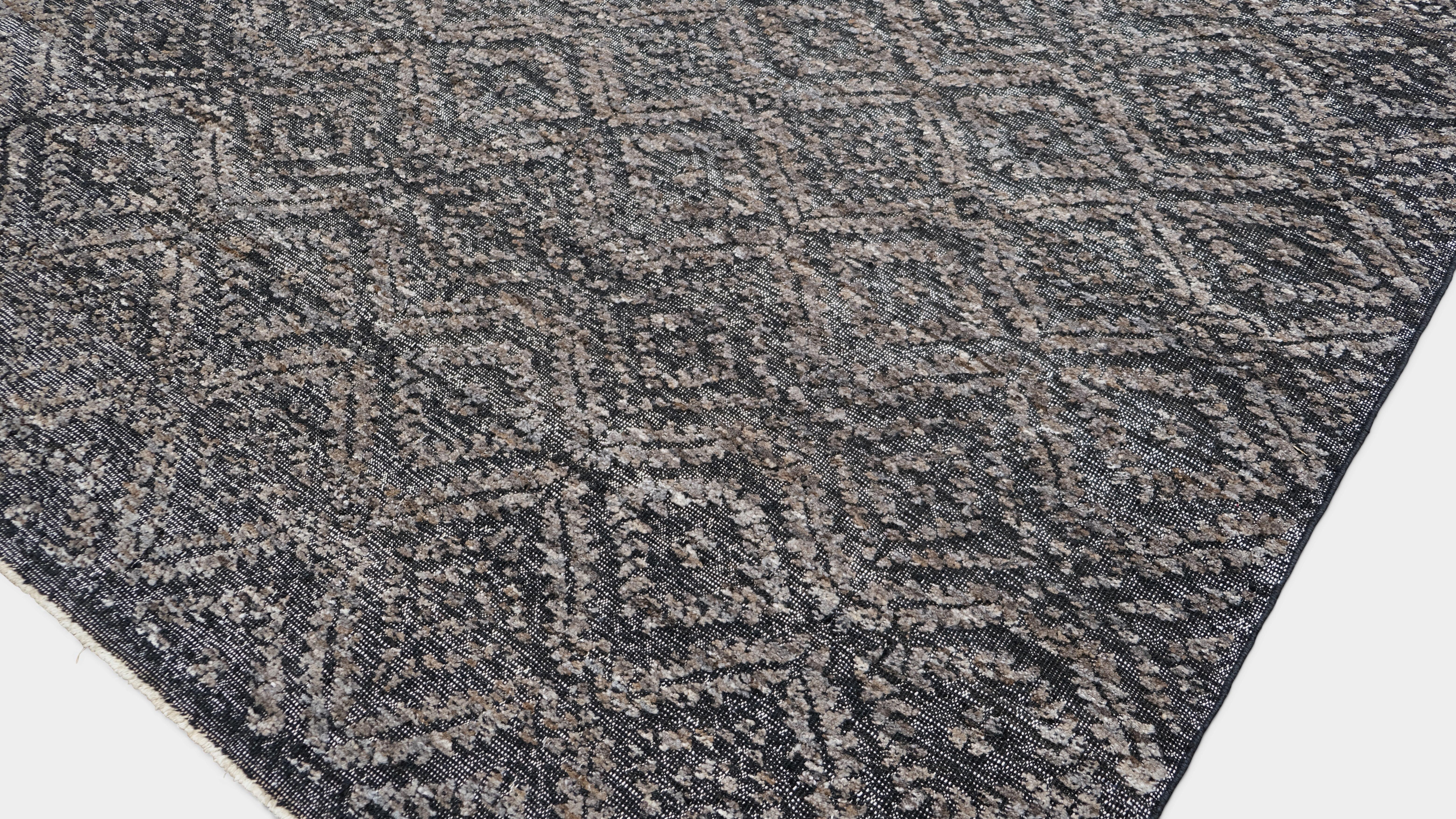 Ce tapis en laine noué à la main présente un motif géométrique sophistiqué, méticuleusement réalisé par des artisans qualifiés. Son tissage texturé high-low crée un jeu captivant d'ombre et de lumière, ajoutant profondeur et dimension aux intérieurs