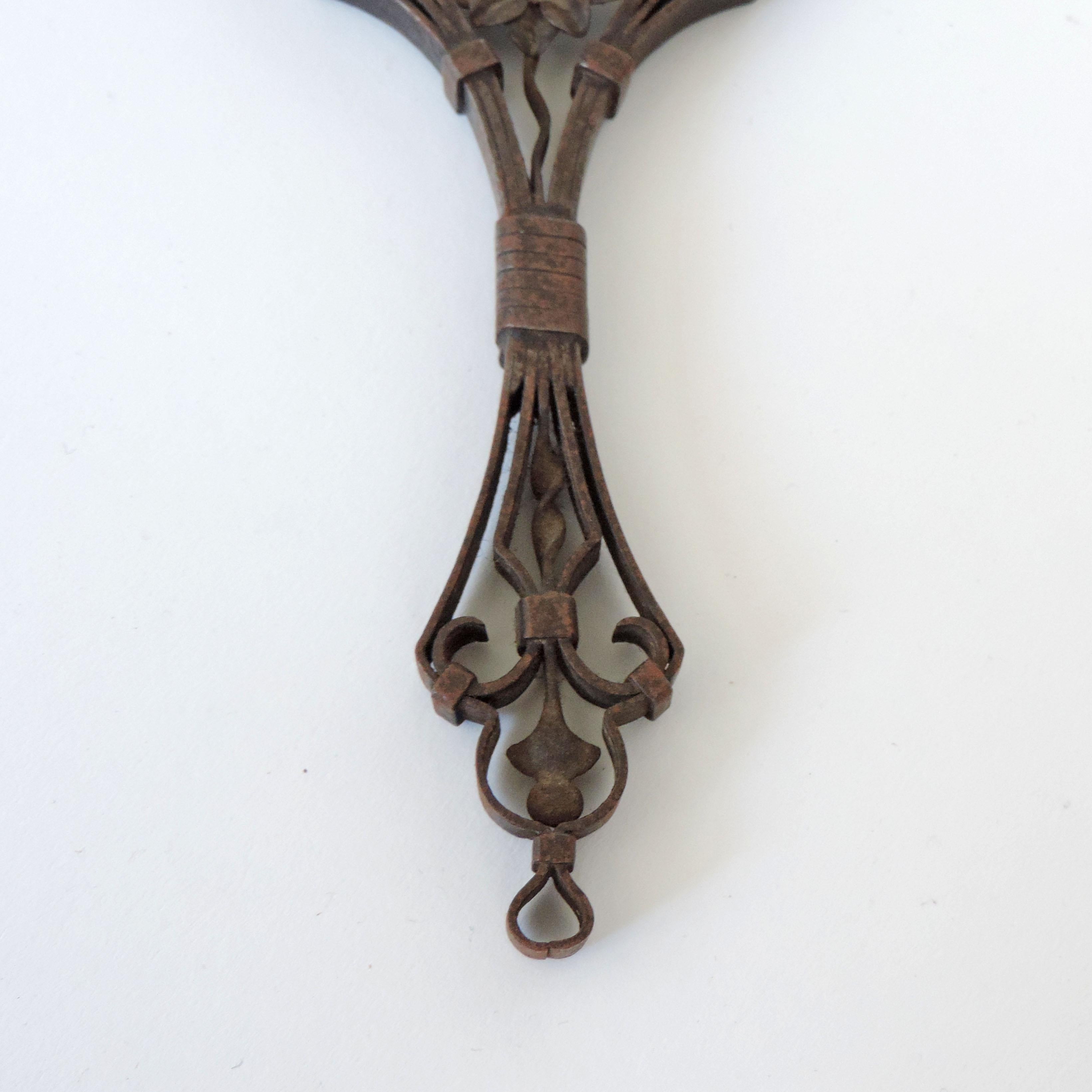 Intricate and meticulous Italian iron hand mirror, 1920s
M initial on the top of mirror.
