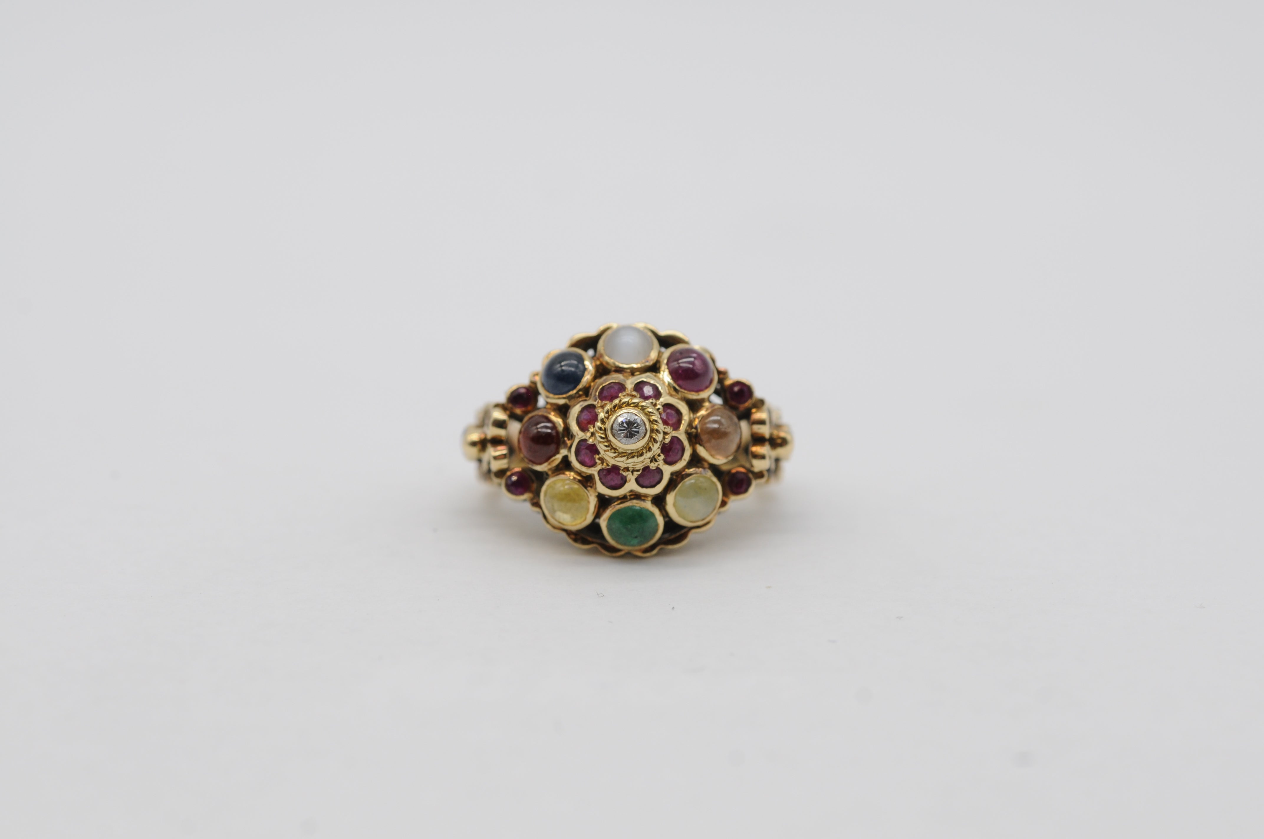 This stunning and intricate oriental ring showcases a delightful array of cabochon-cut gemstones, each carefully selected to highlight the beauty and craftsmanship of this exquisite piece. a ruby a sapphire, a smoky quartz, a vibrant emerald, a deep