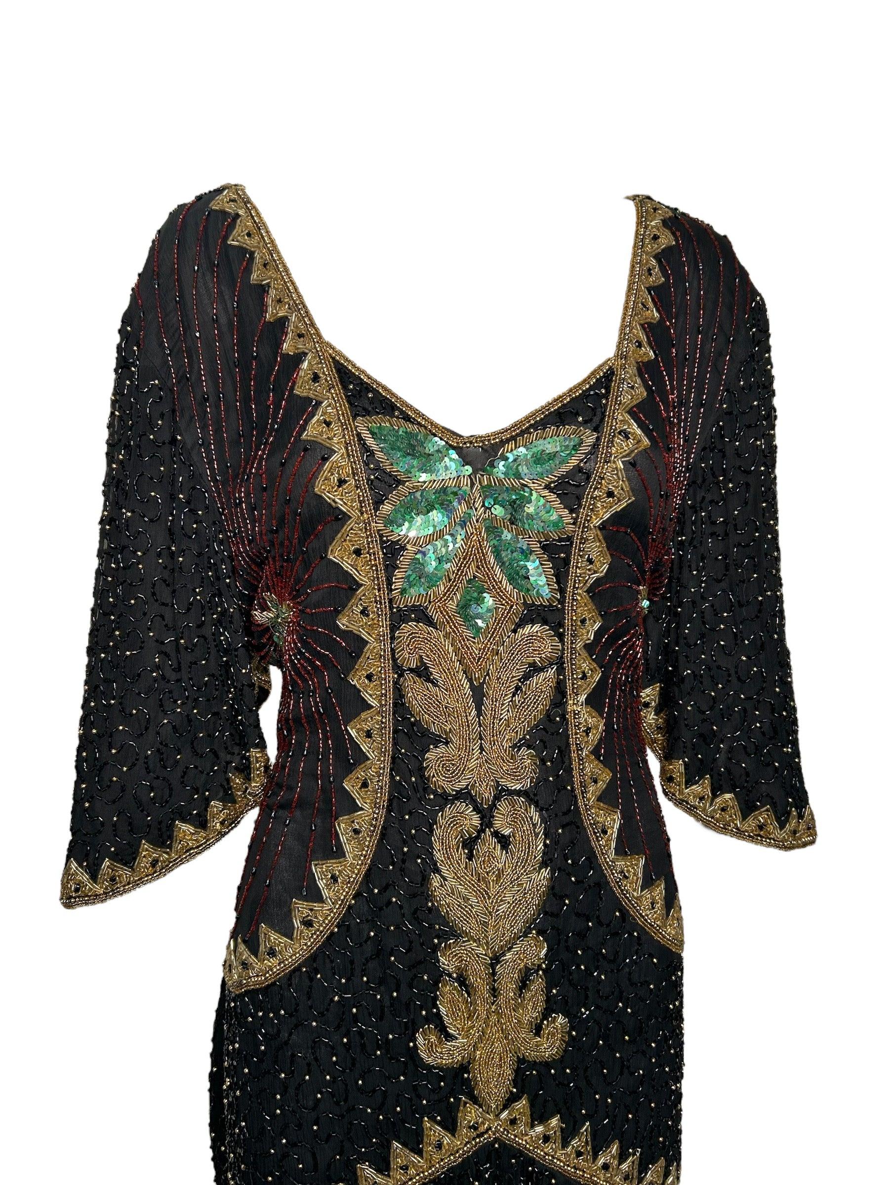 80er Jahre Perlenbesetztes Schwarz & Gold Festtagskleid. Abgewinkelte Ärmel und aufwendige Perlenstickerei e mit floralem Smaragdmuster in der vorderen Mitte. In gutem Vintage-Zustand. Reißverschluss und Haken hinten. Satin-Rückenschärpe zum