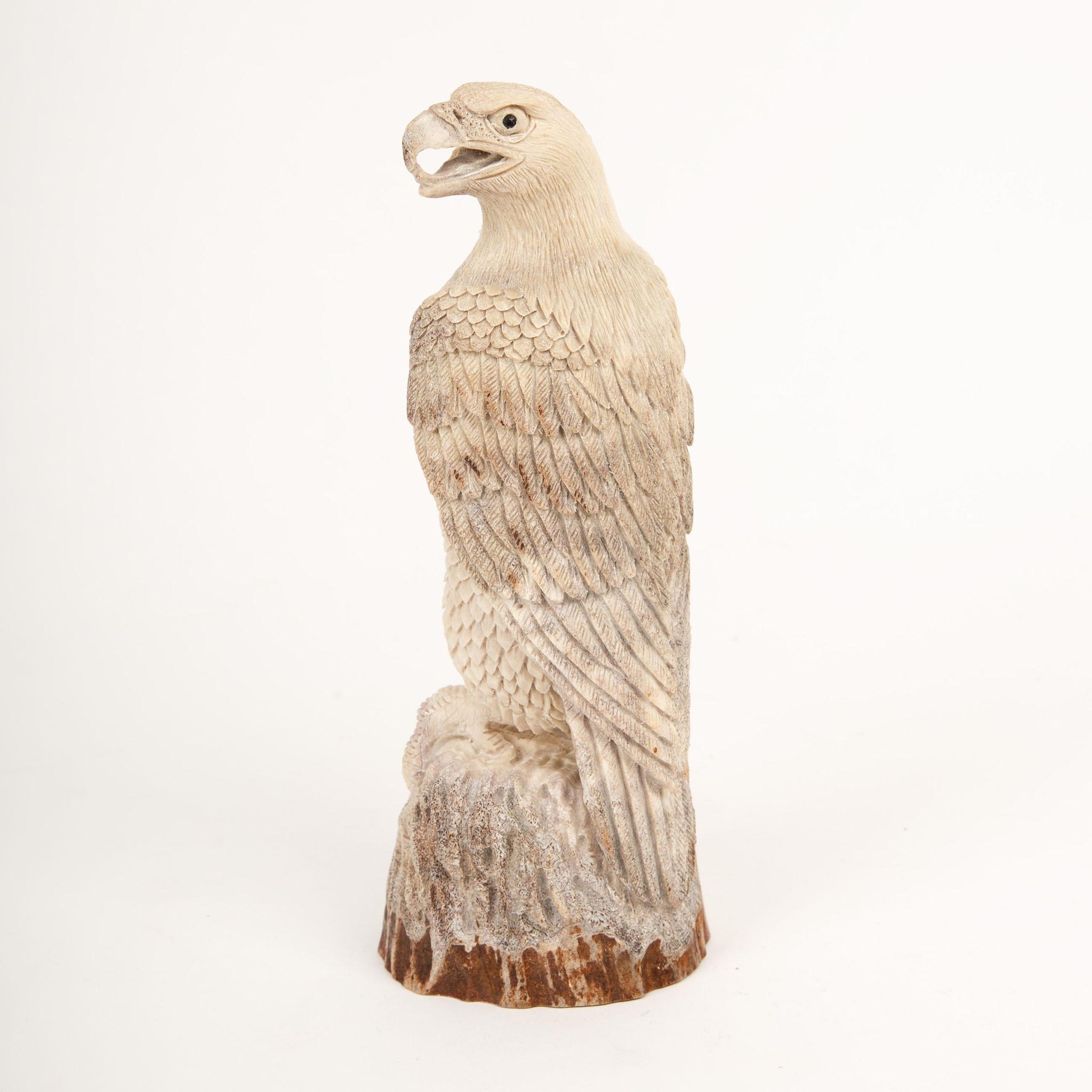 Sculptée à la main en Indonésie à partir de bois d'élan d'Amérique du Nord, cette sculpture finement détaillée représente un aigle majestueux perché sur un socle texturé. L'artisan a habilement utilisé la coloration naturelle et le grain du bois de