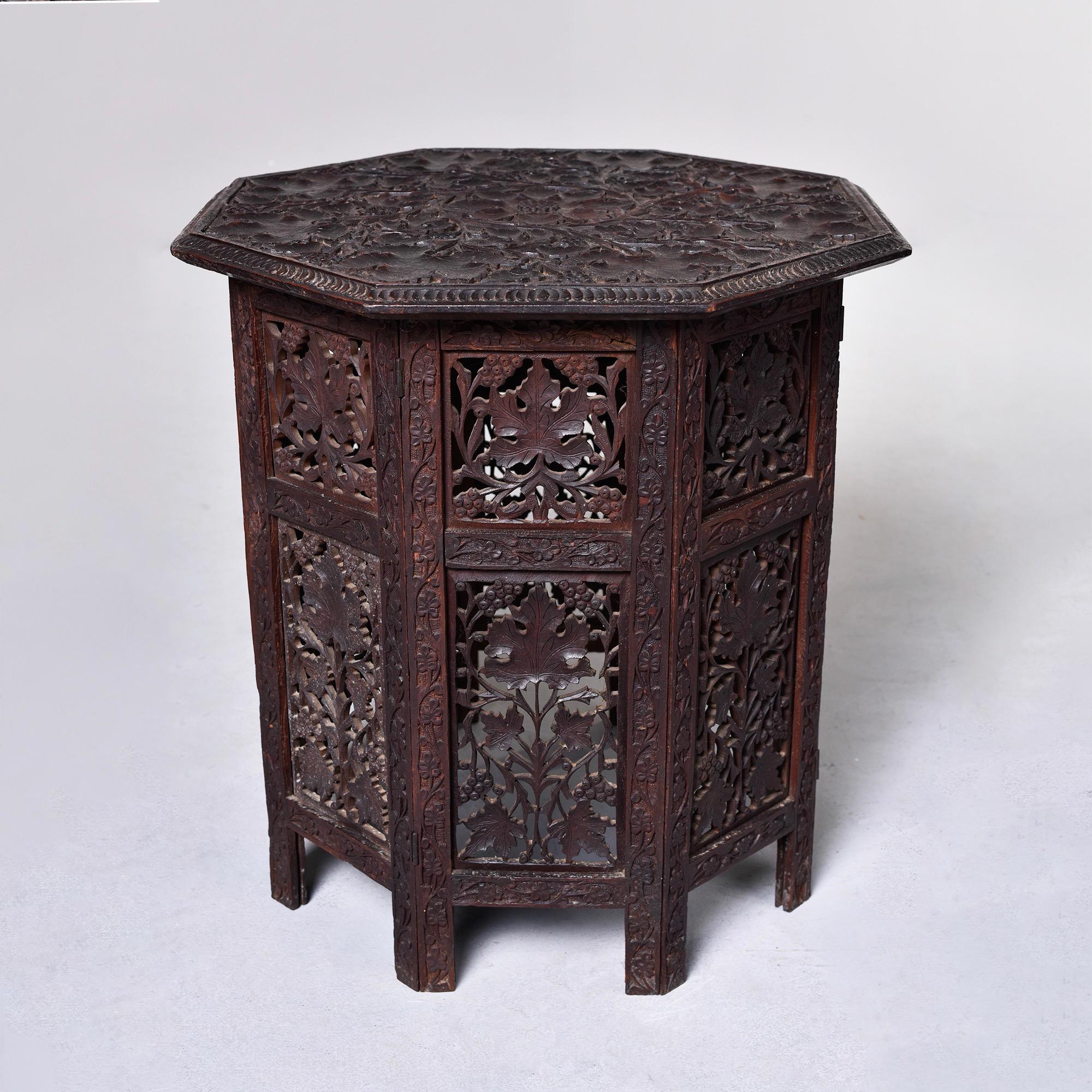 Circa 1960s intricately carved dark stained teak side table in Moorish design. Top can lift off and sides are hinged so this can be folded flat for low-cost shipping option. Unknown maker.