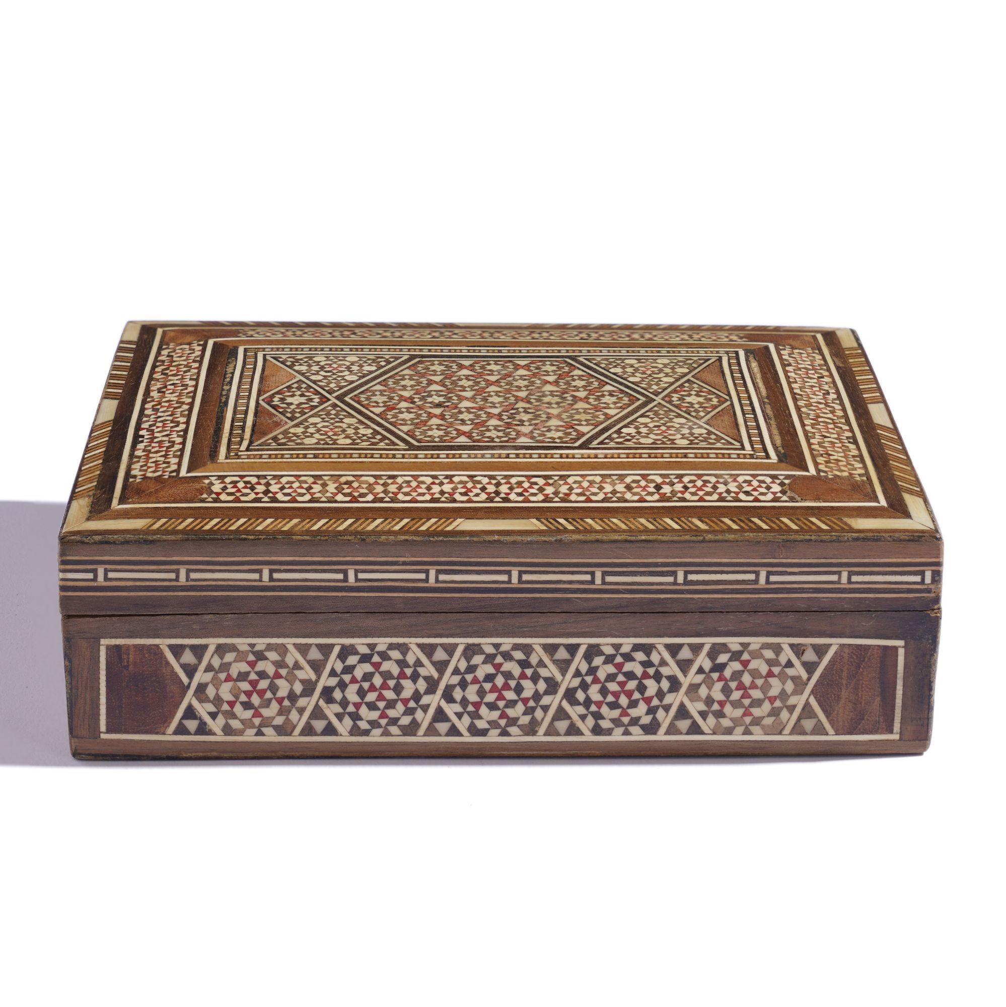 Caja de Damasco vintage con intrincadas incrustaciones y tapa abatible de madera dura, sándalo, ébano y hueso de camello. La caja presenta un campo geométrico incrustado en cinco lados junto con un borde en forma de banda con cordones. El interior