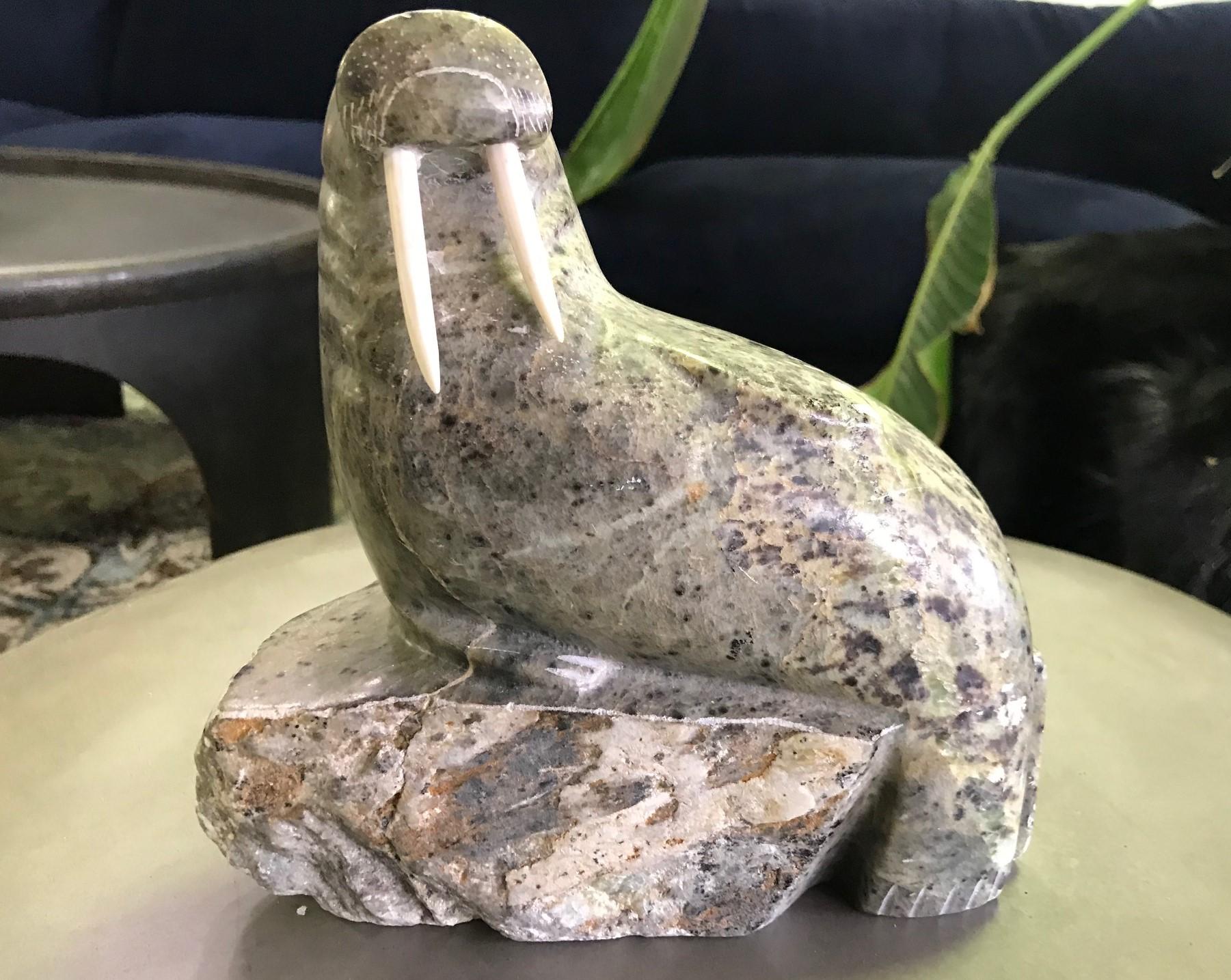 A wonderful soapstone carving of a walrus with tusks by the indigenous Inuit people who inhabit parts of the Arctic regions of Greenland, Canada, and Alaska.

Some markings to the underside but they appear too random to be a signature but perhaps