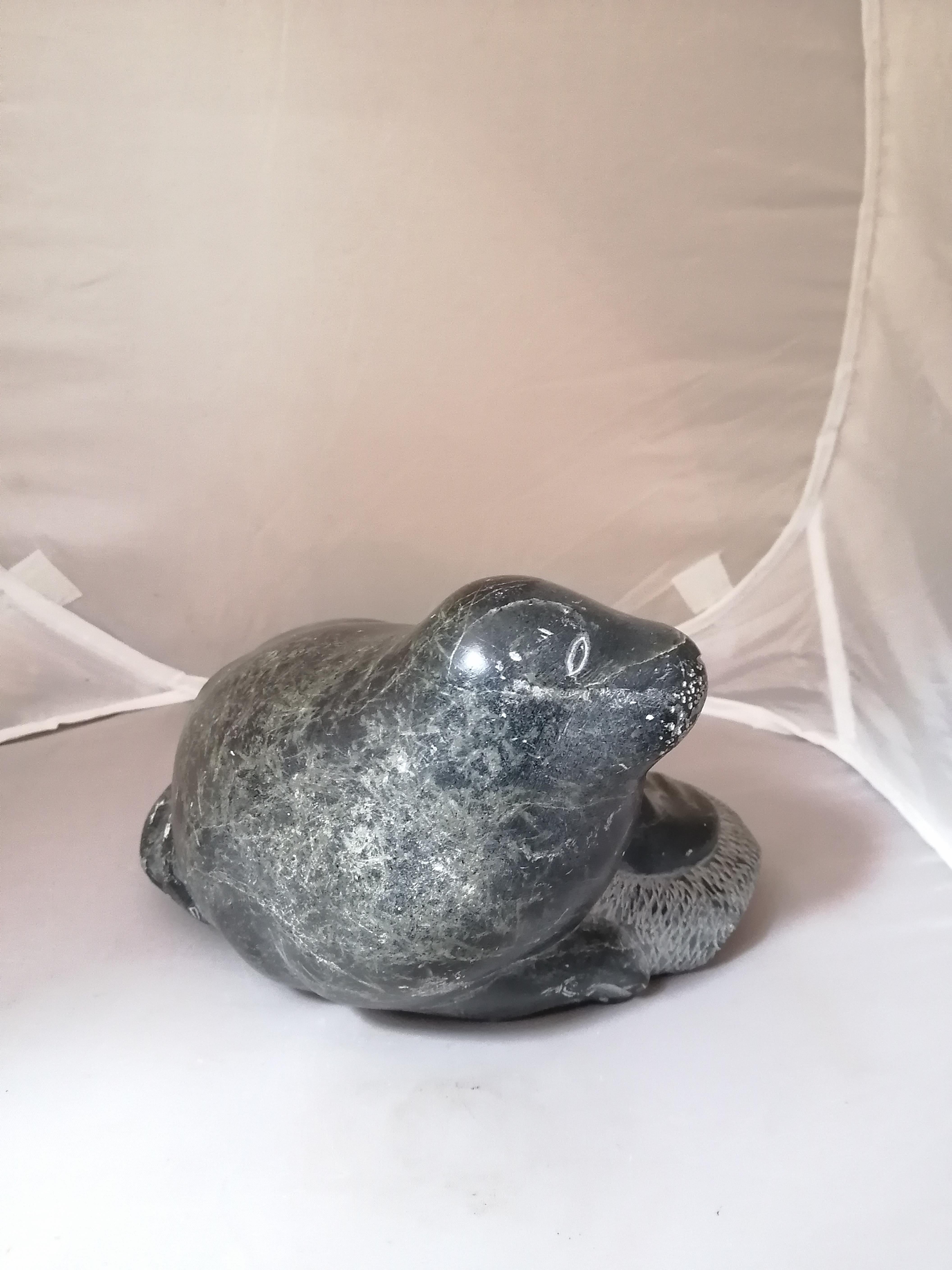 A big Inuit soapstone sculpture depicting a sea lion. The sculpture is signed on the bottom by an unidentified artist and numbered 202266. With Canada Eskimo Art seal.