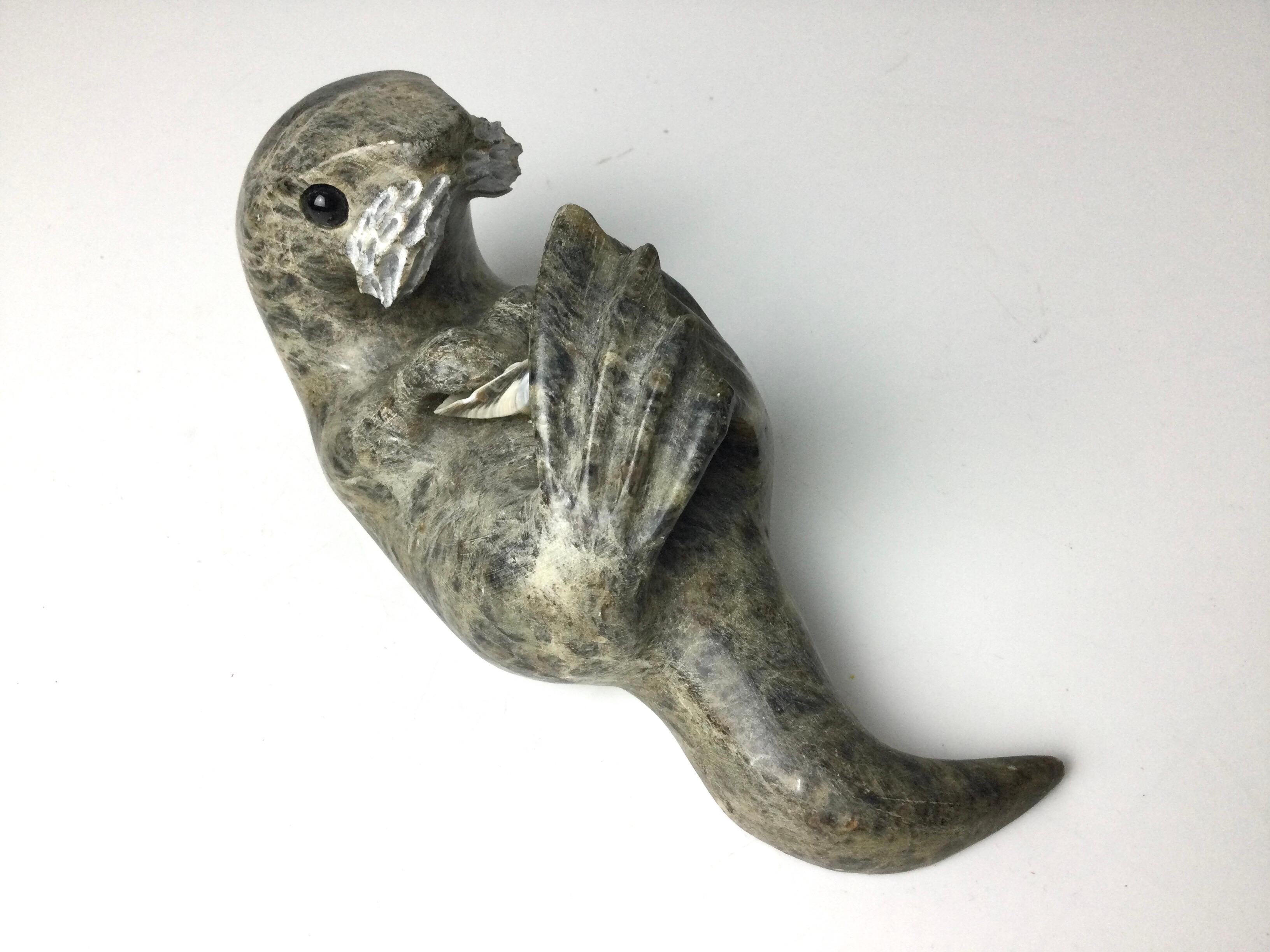 This is a wonderful Inuit carving of an otter playing with a shell. 7” long by 3” by 3” tall. Signed on bottom.