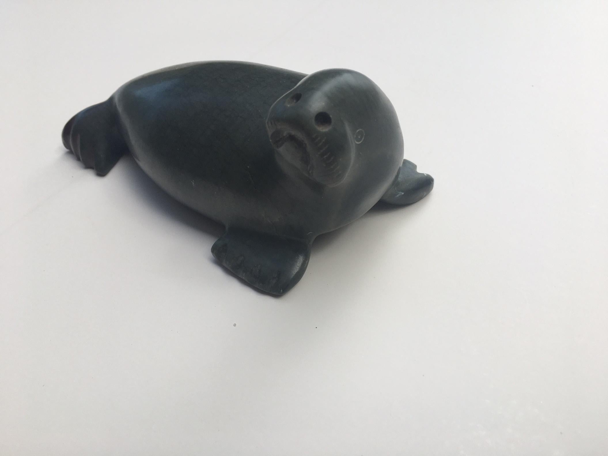 Inuit Stone Seal sculpture carving by Pauta Saila 1916 - 2009

Excellent and smooth polished stone carving of a seal. It is perfectly sculpted in a reclining position with its head lifted. An expressive face with nostrils and beard, shows great