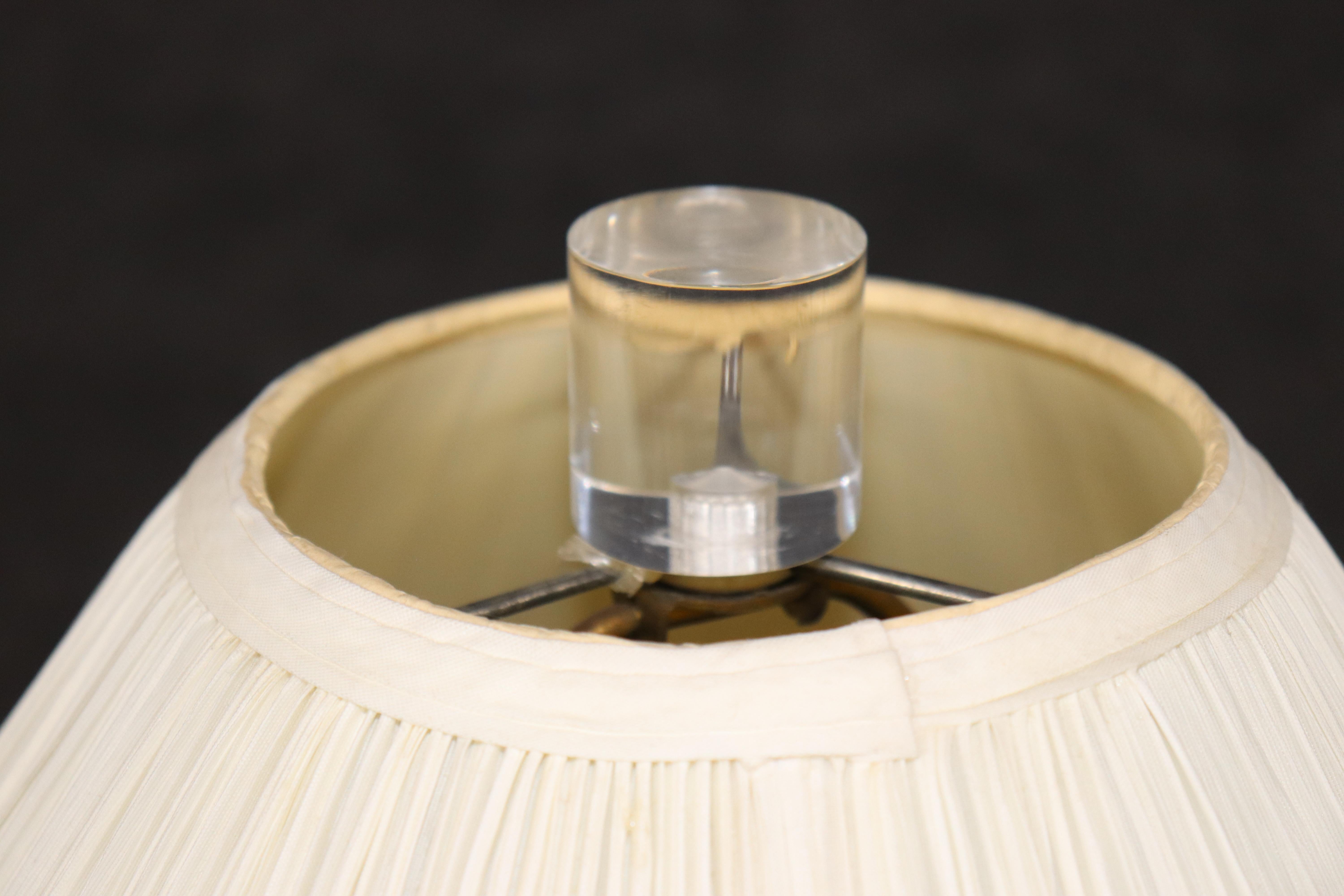This is a gorgeous brass and lucite Maison Jansen style table lamp. The lamp is in good condition with minor losses of patina on the brass and minor signs of use and age. Measures with lampshade 17 x17 x 37.75 and without the shade measures 27
