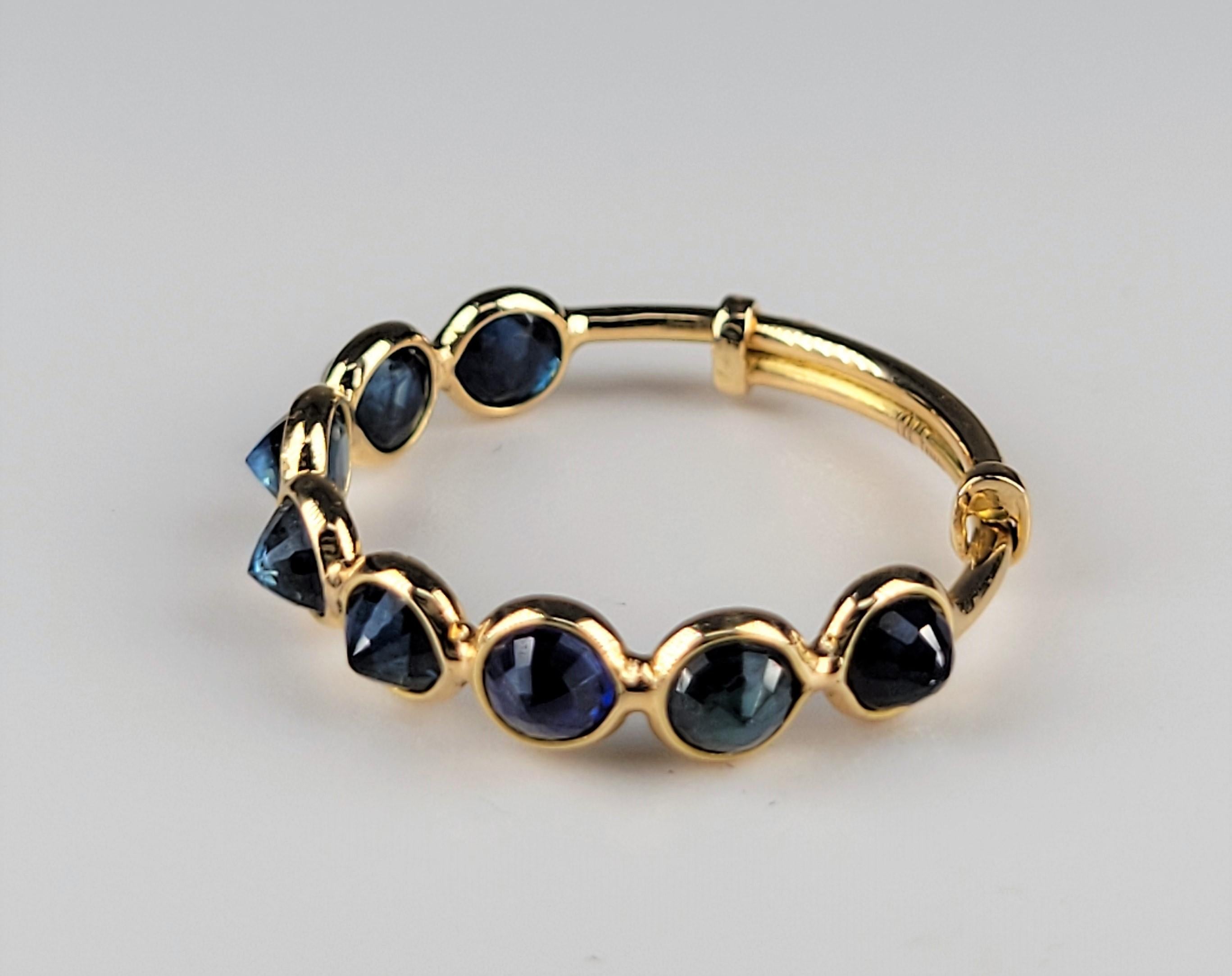 Inverted blue sapphires are striking against the 18 karat yellow gold, adjustable mounting!