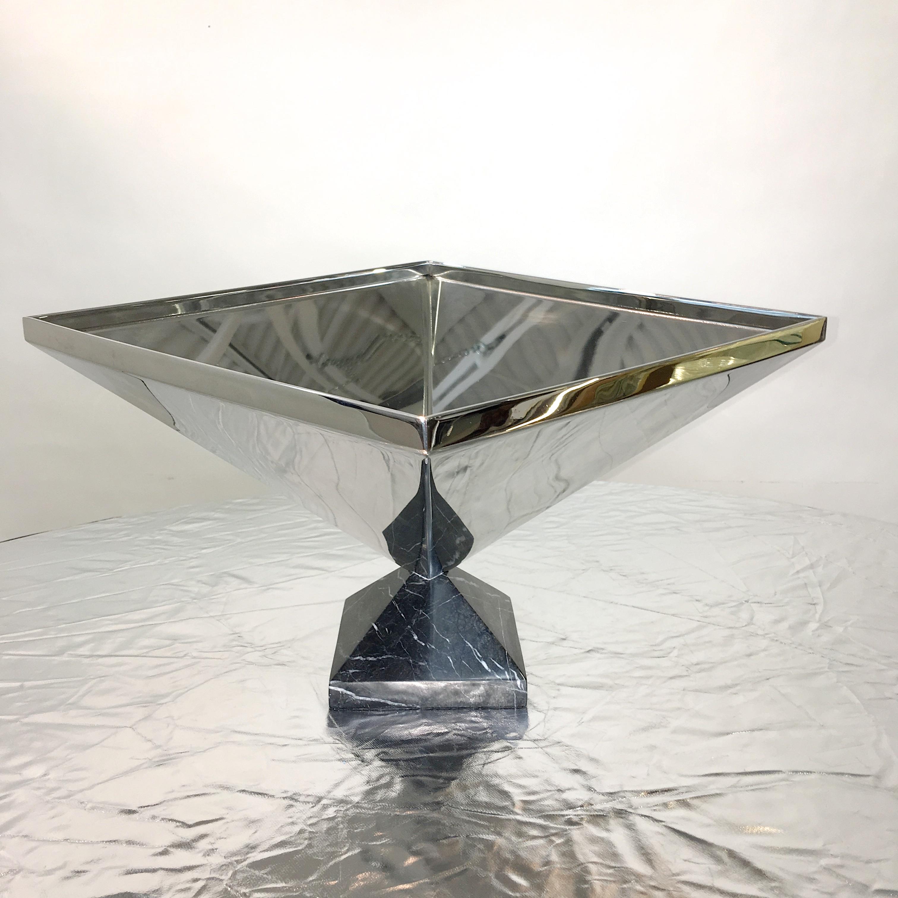 Sculptural mirror polished stainless steel centerpiece bowl or vase handcrafted in the form of an inverted pyramid standing point to point on a nero marquina marble base also in pyramidal form though smaller. 

Unmarked but attributed to