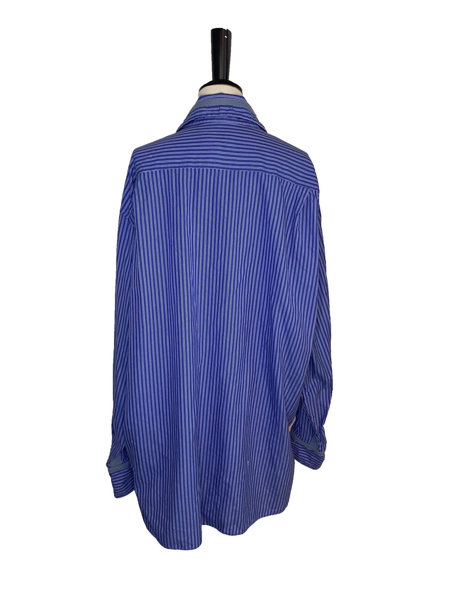 Vintage cotton blue striped gents shirt from Voyage . Front button fastening with small pearl coloured buttons. Collar. Buttoned cuffs. Signature contrasting blue ribbon around collar, cuffs and down each side of the shirt. Made in England. Marked