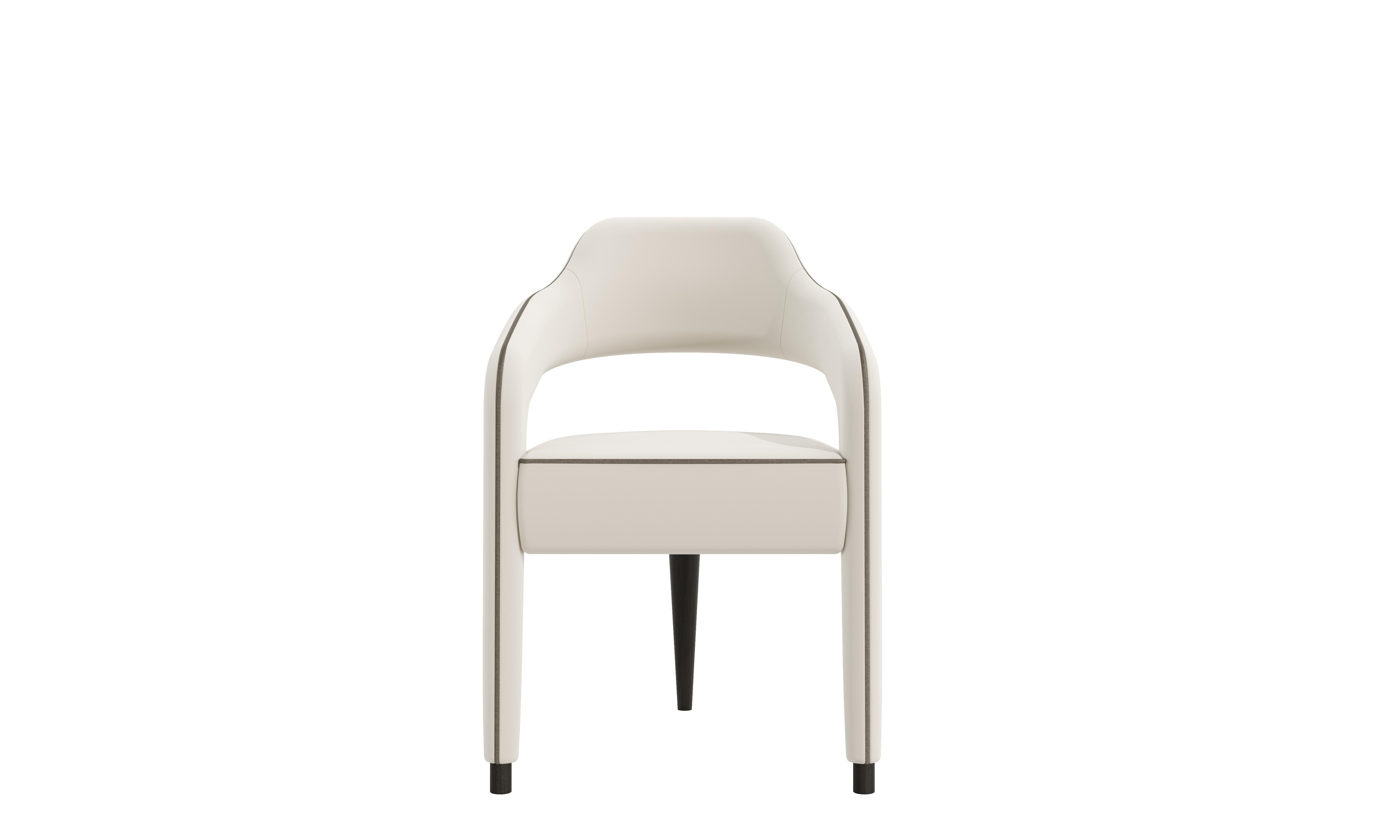 The INVICTA chair by Casa Magna is a captivating piece that combines bold design with exceptional craftsmanship. This iconic chair features a striking single solid wood back leg that complements its sculptural form. Its silhouette is elegantly