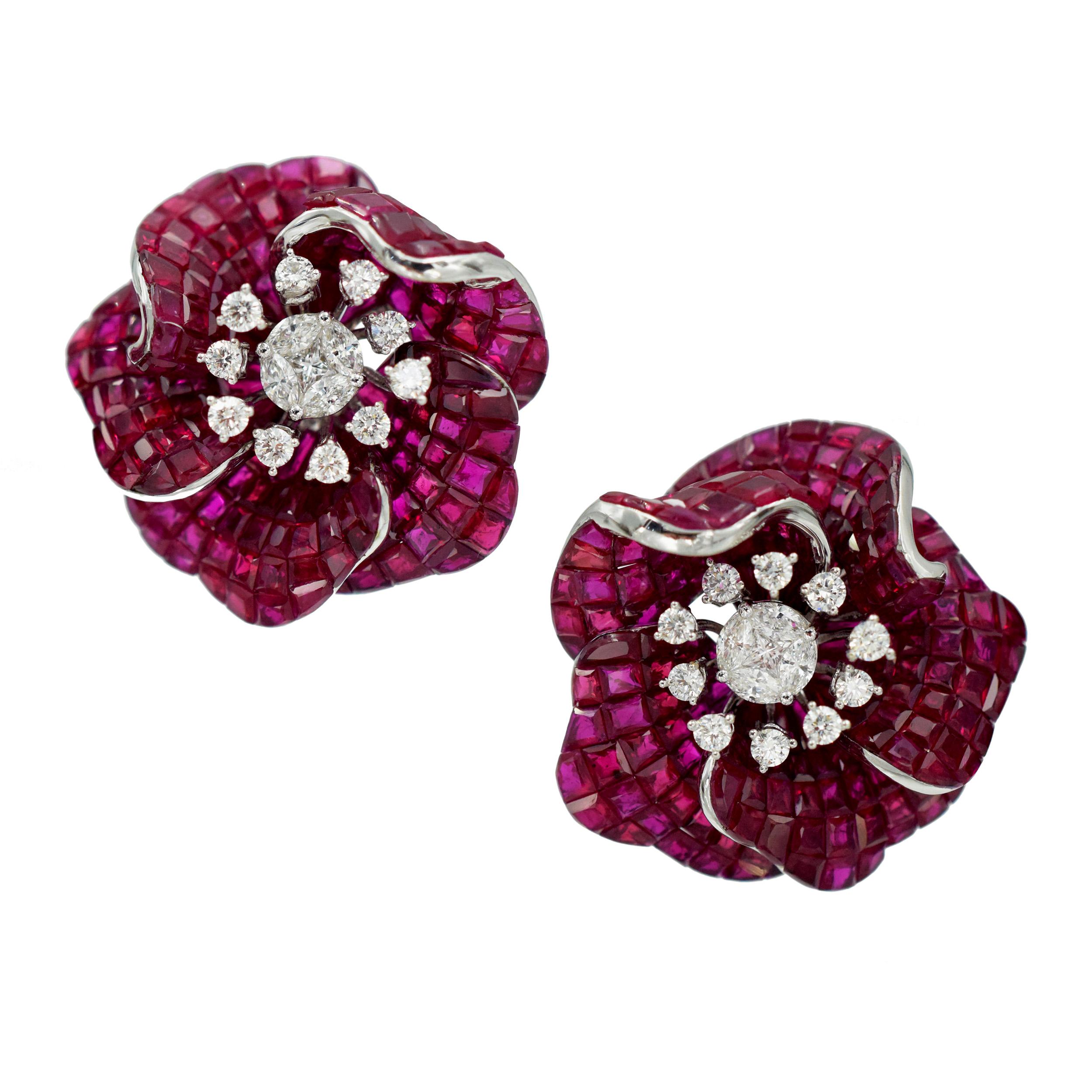 Flower ruby and diamond earrings. Crafted in 18k white gold. Each flower consists of five petals,
each invisibly set with square cut rubies with total weight of 64.50ct. Each center set with one cushion cut and four marquise cut diamonds, surrounded