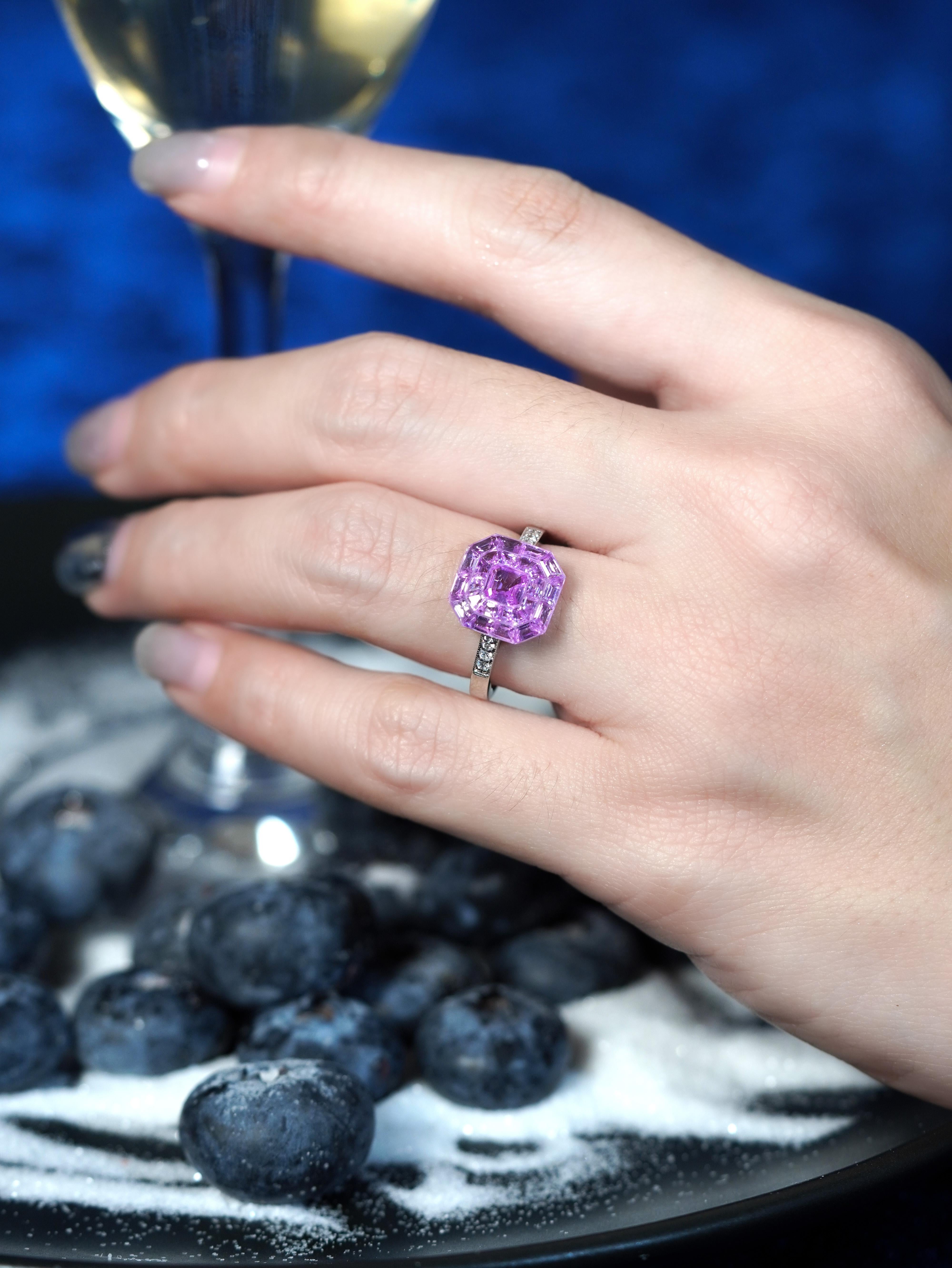 Irradiando elegancia Art Decó, este anillo presenta un zafiro rosa engastado con un magistral engaste invisible, que permite que la gema aparezca suspendida a la perfección. Los diamantes adornan los hombros, añadiendo un brillo sutil y realzando el