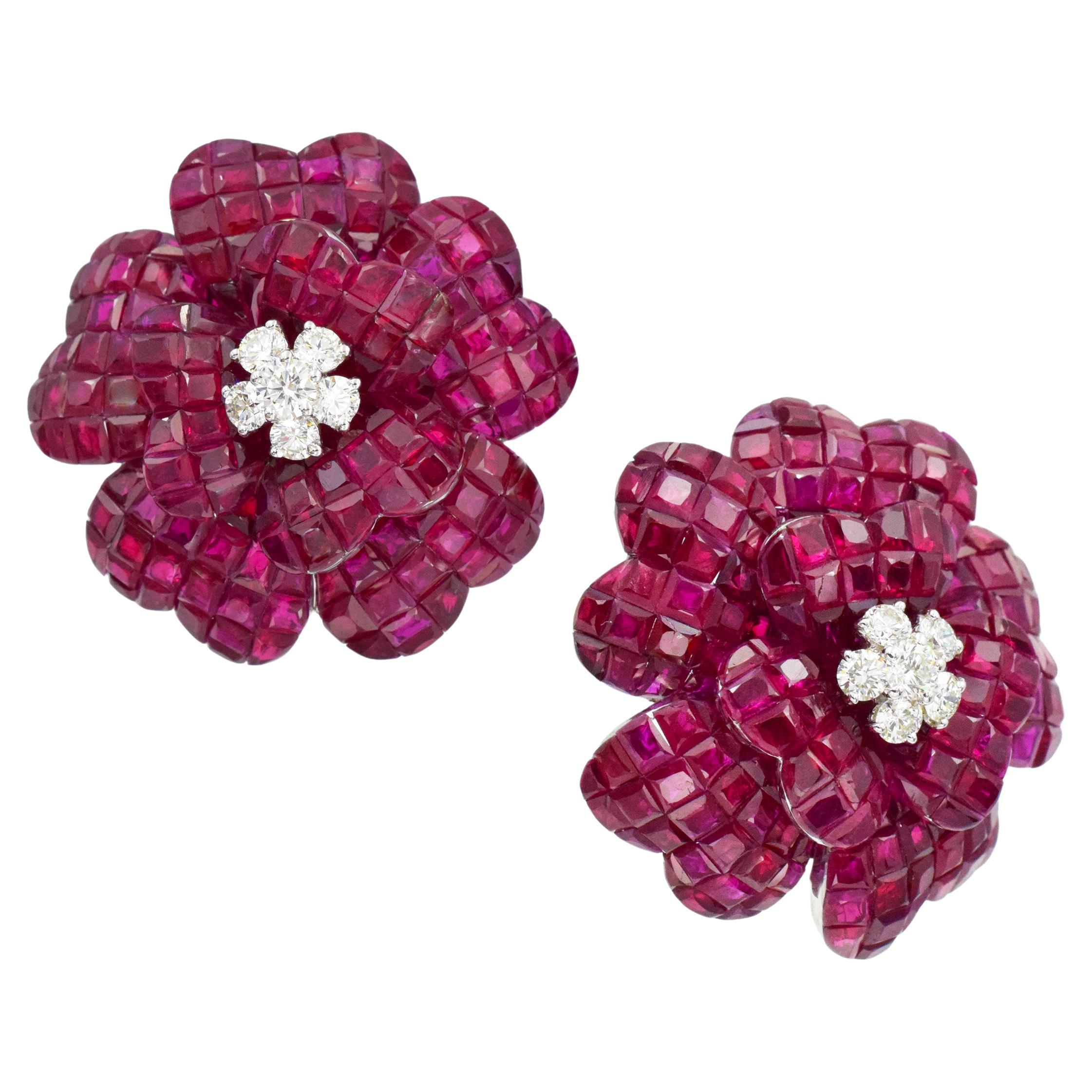Blooming flower ruby and diamond earrings. Crafted in 18k white gold. Each flower consists of five larger and three smaller petals, each invisibly set with square cut rubies with total weight of 69.45ct. Centers set with total of ten round diamonds