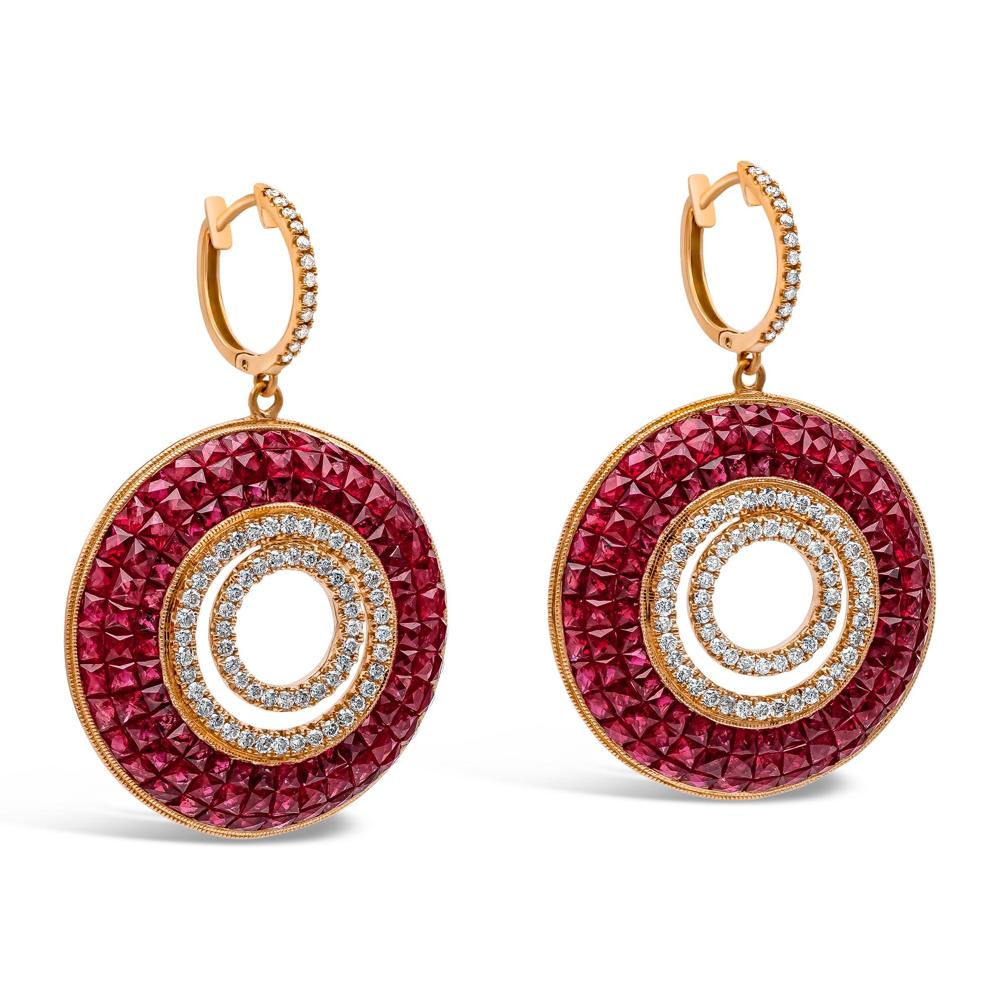 A beautiful and intricately-designed pair of dangle earrings showcasing a cluster of perfectly-matched rubies, invisibly set in an 18k rose gold mounting. The earrings are accented with round brilliant diamonds and is suspended on a rose gold hoop.