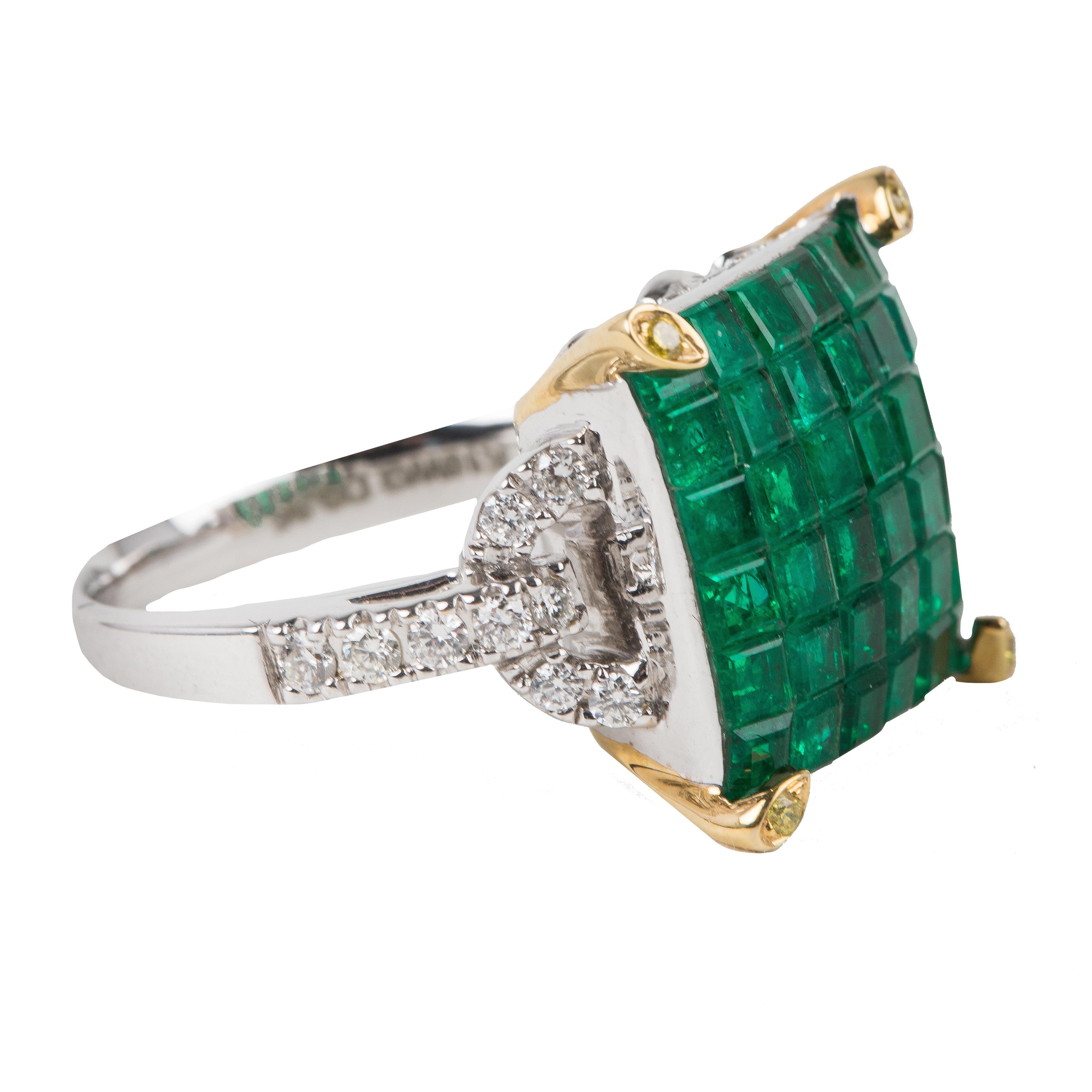 This emerald ring is comprised of 36 stones that have been invisibly set in the ring with gold-tone lobster prongs. This ring is surrounded by diamonds. 