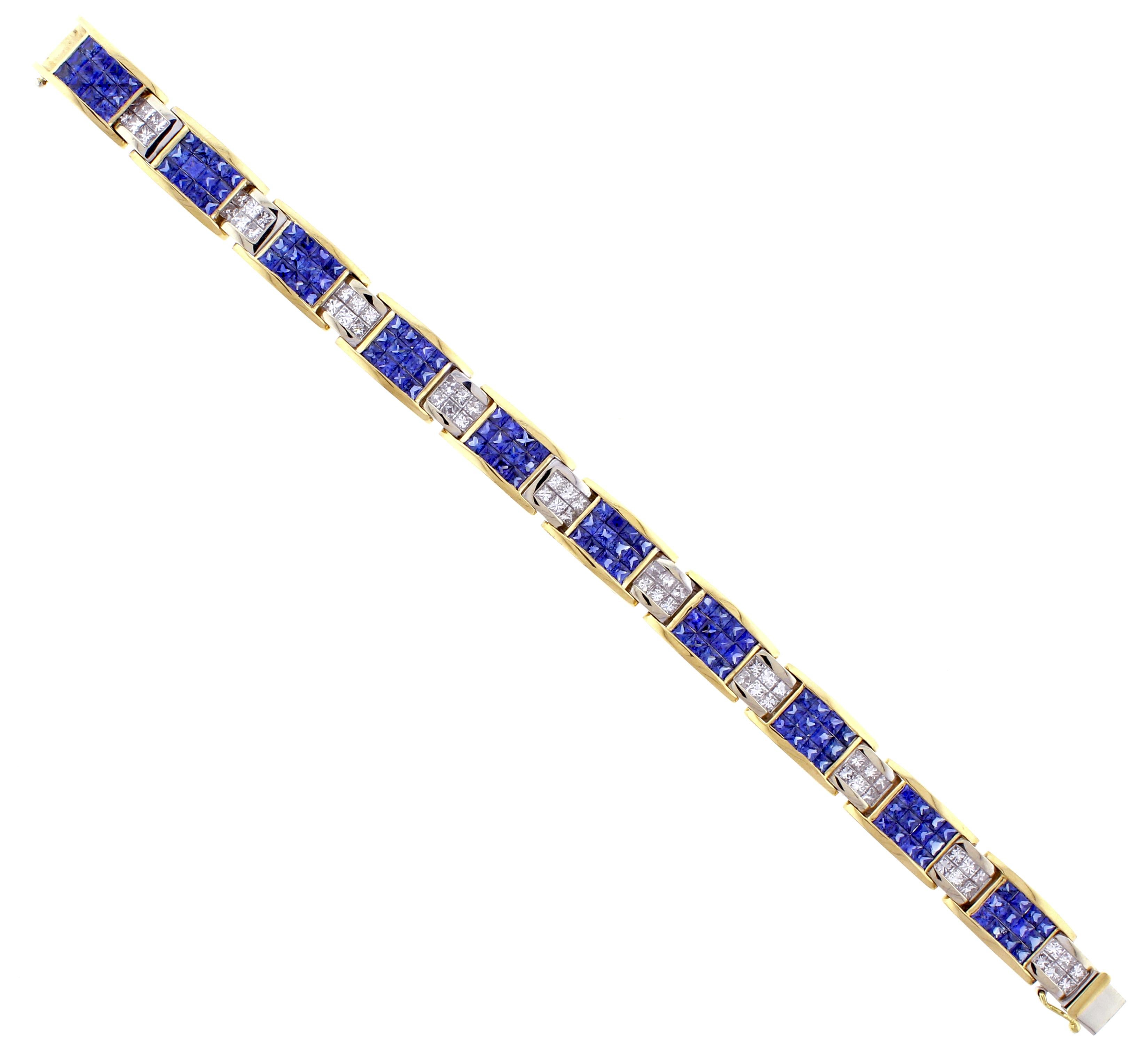 This bold  18 karat  white and yellow gold sapphire and diamond bracelet is comprised of 120 invisible set princess cut sapphires weighing approximately 14.4 carats and 60 invisible set princess cut diamonds weighing approximately  6 carats. The