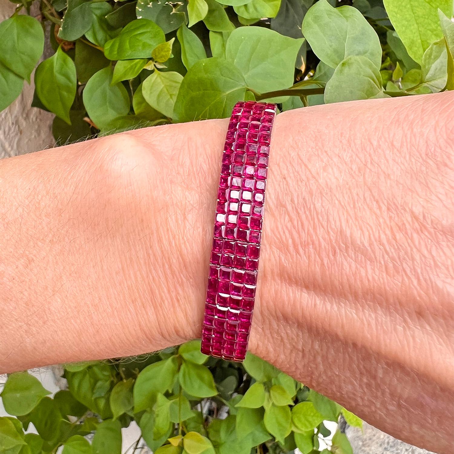Elegant modern line bracelet, showcasing four rows of faceted square-shaped natural rubies invisibly-set in 18k white gold.  272 rubies weighing 47.56 total carats.  Beautifully articulated design of the bracelet allows the gem rubies to glisten