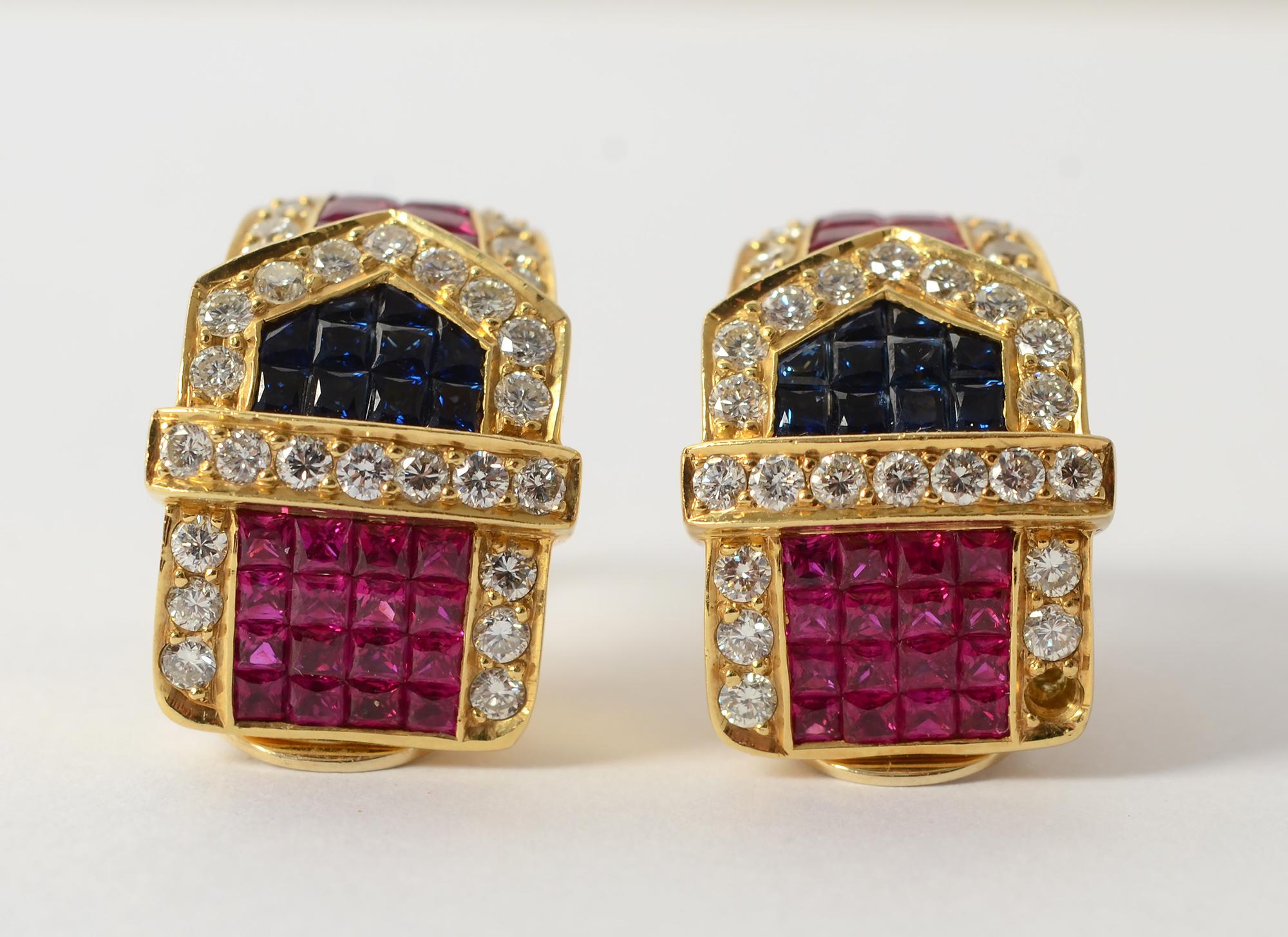 Elegant and sparkly half hoop buckle earrings with invisibly set rubies and sapphires and outlined with diamonds. The earrings taper slightly at the bottom  and are half an inch wide at the top. They are nearly one inch in length.
Backs are clips