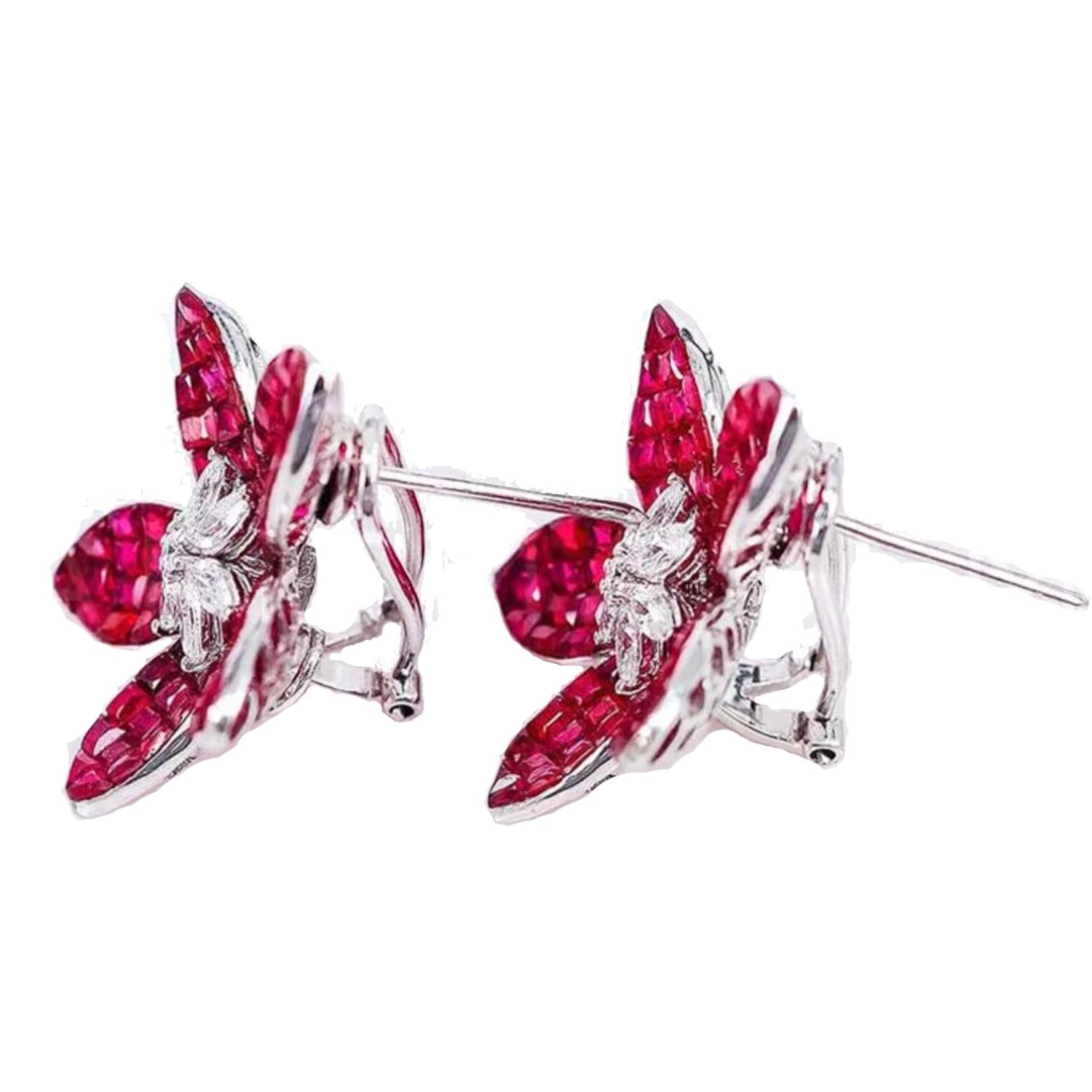 Invisibly-set ruby and diamond lotus flower earrings, designed with five calibre-cut ruby-set petals surrounding a cluster of marquise and round brilliant-cut diamonds at center. Handcrafted in polished 18k white gold.

Rubies weighing 23.50 total